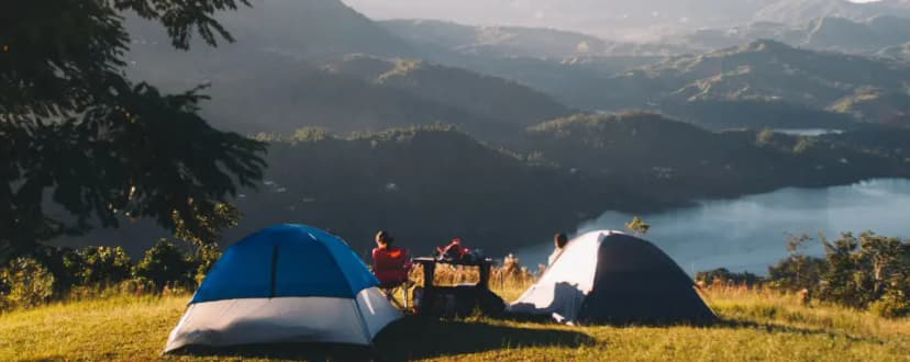 Image of people camping outside overlooking a lake