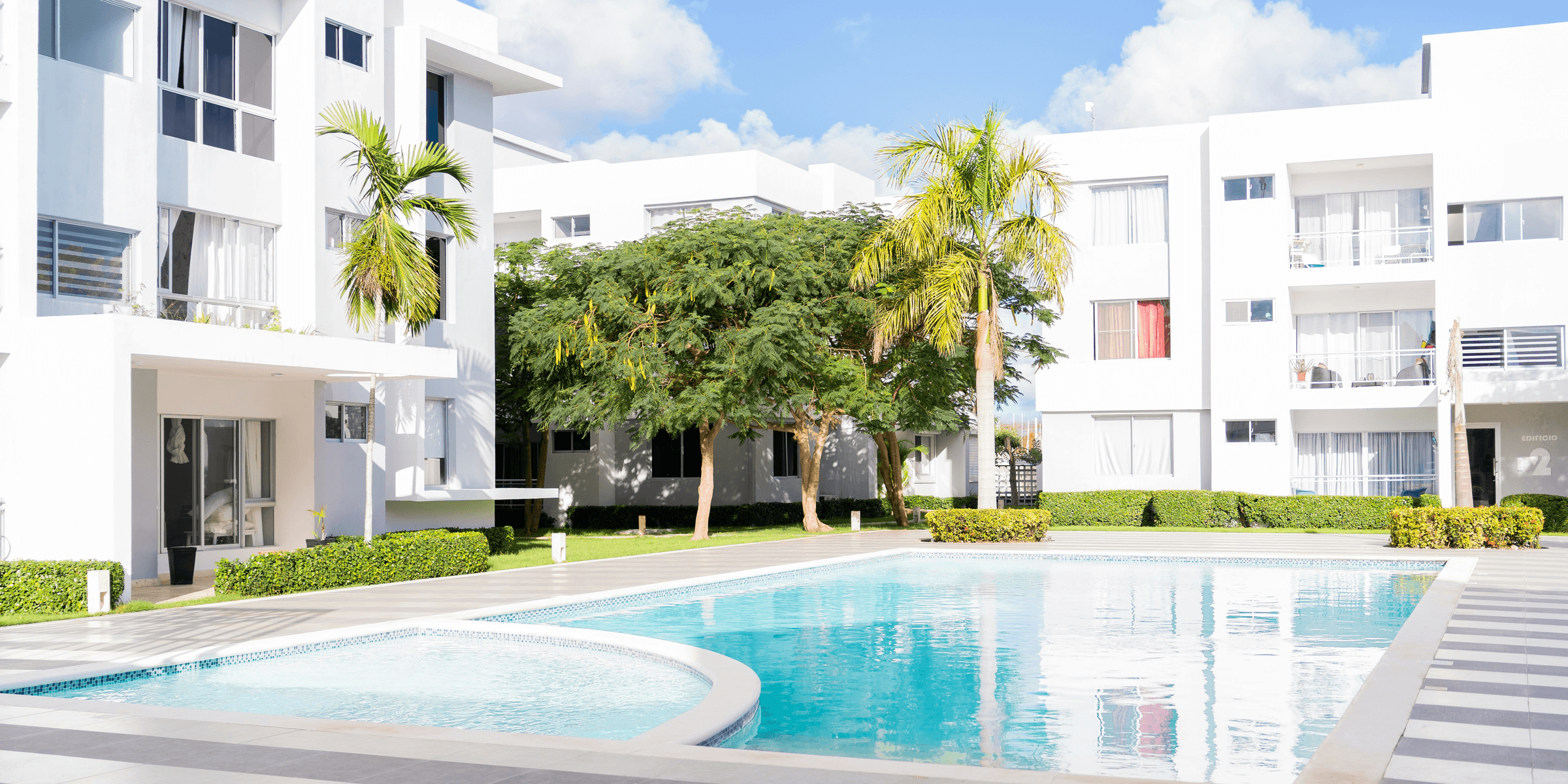 A swimming pool in front of a white building