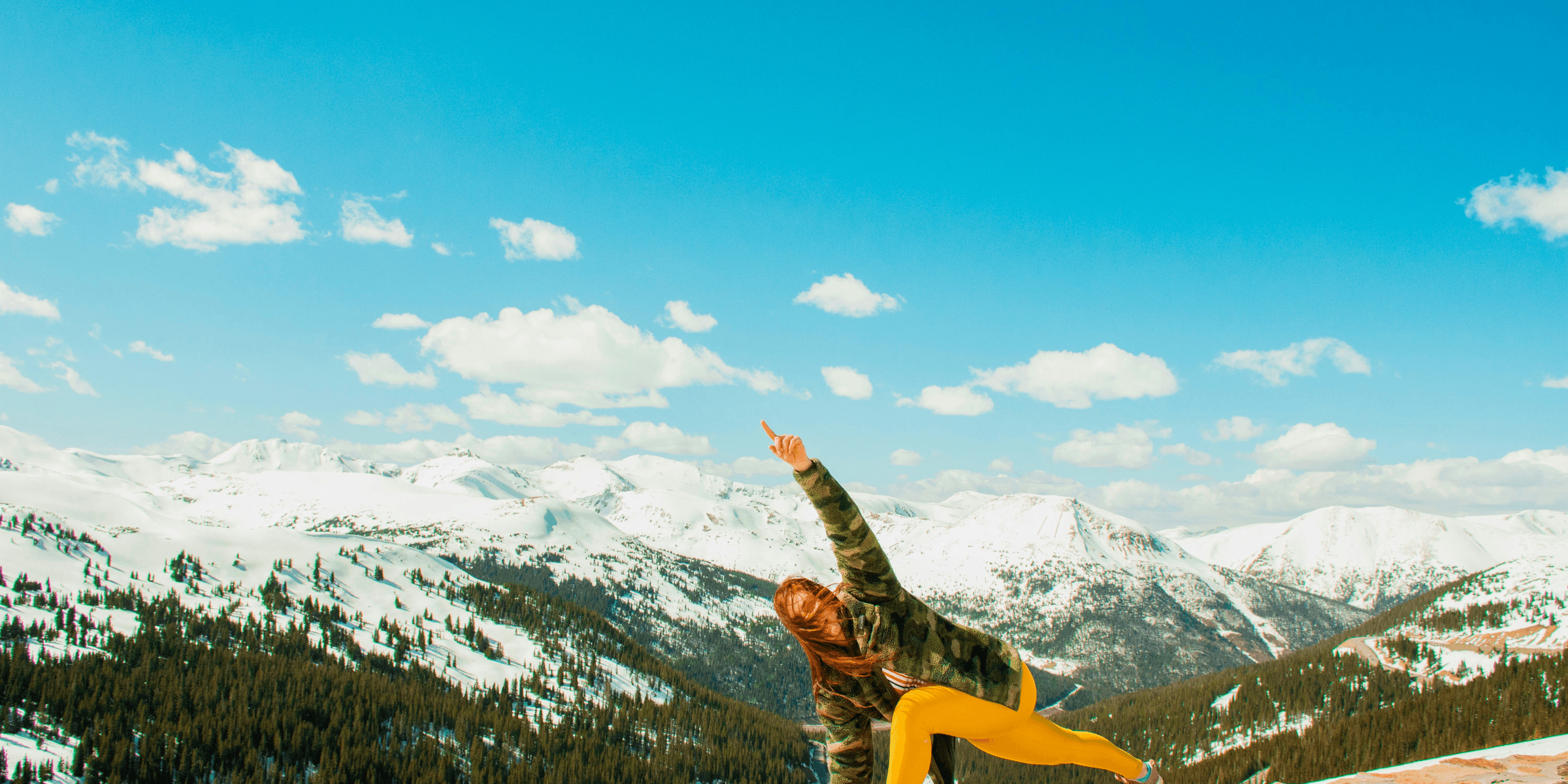 woman performing yoga on cliff