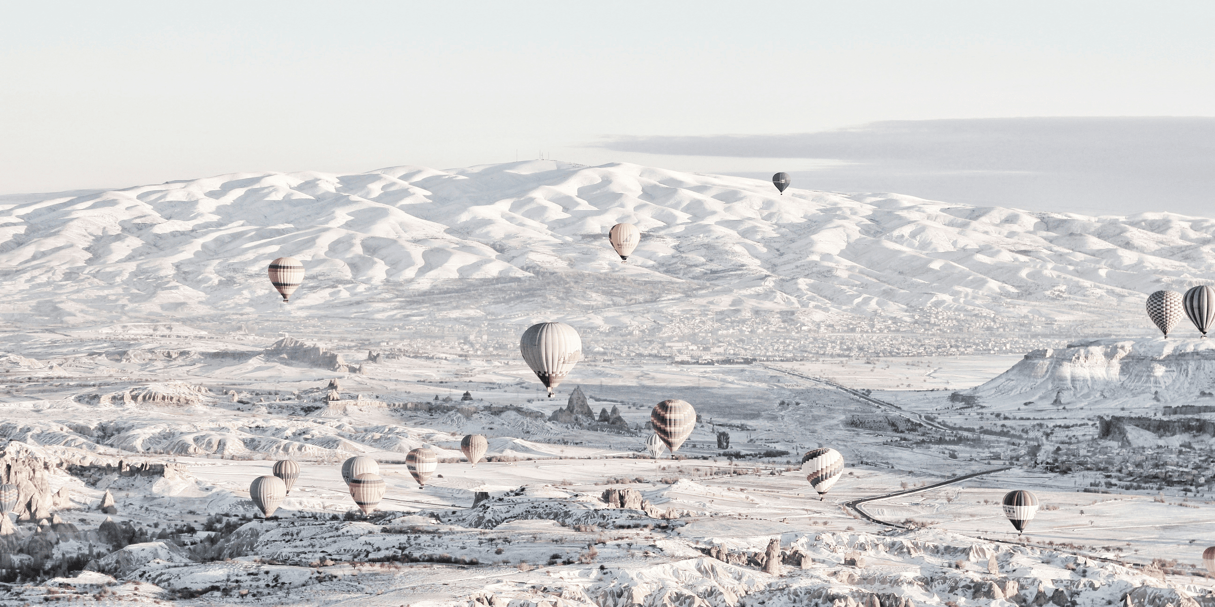 assorted-color air balloons below snowland at daytime