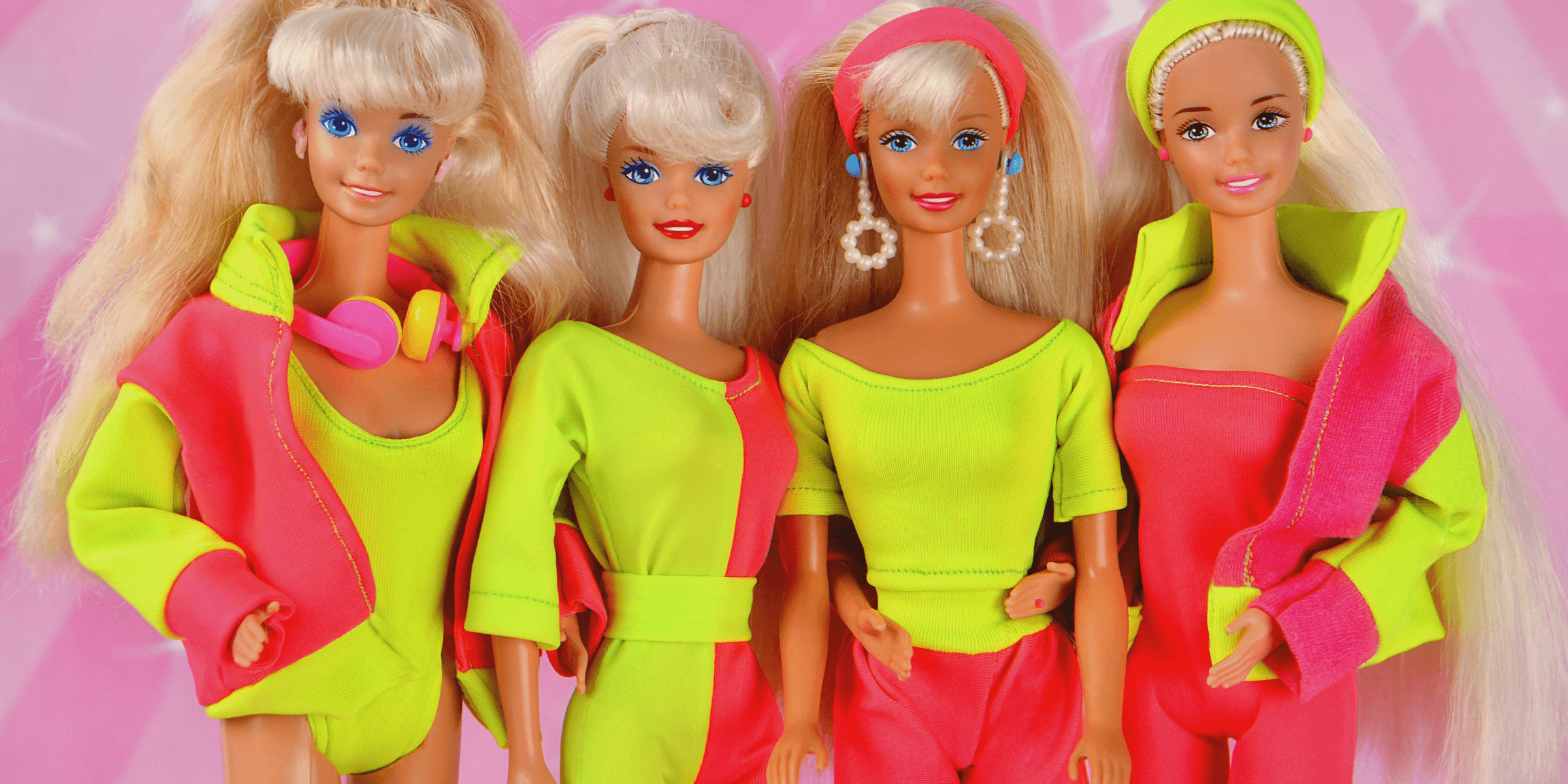 Four 80s barbie dolls posing together.