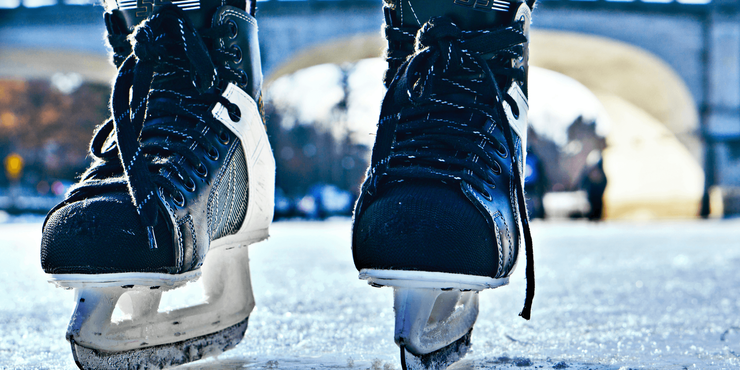 close-up photo of black-and-gray Intruder ice skates on frozen body of water