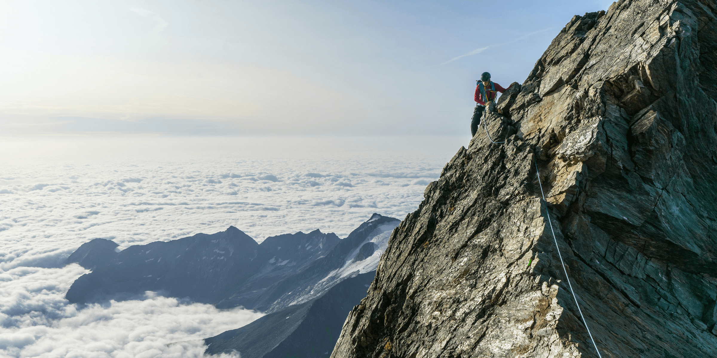 man climbing on gray mountain