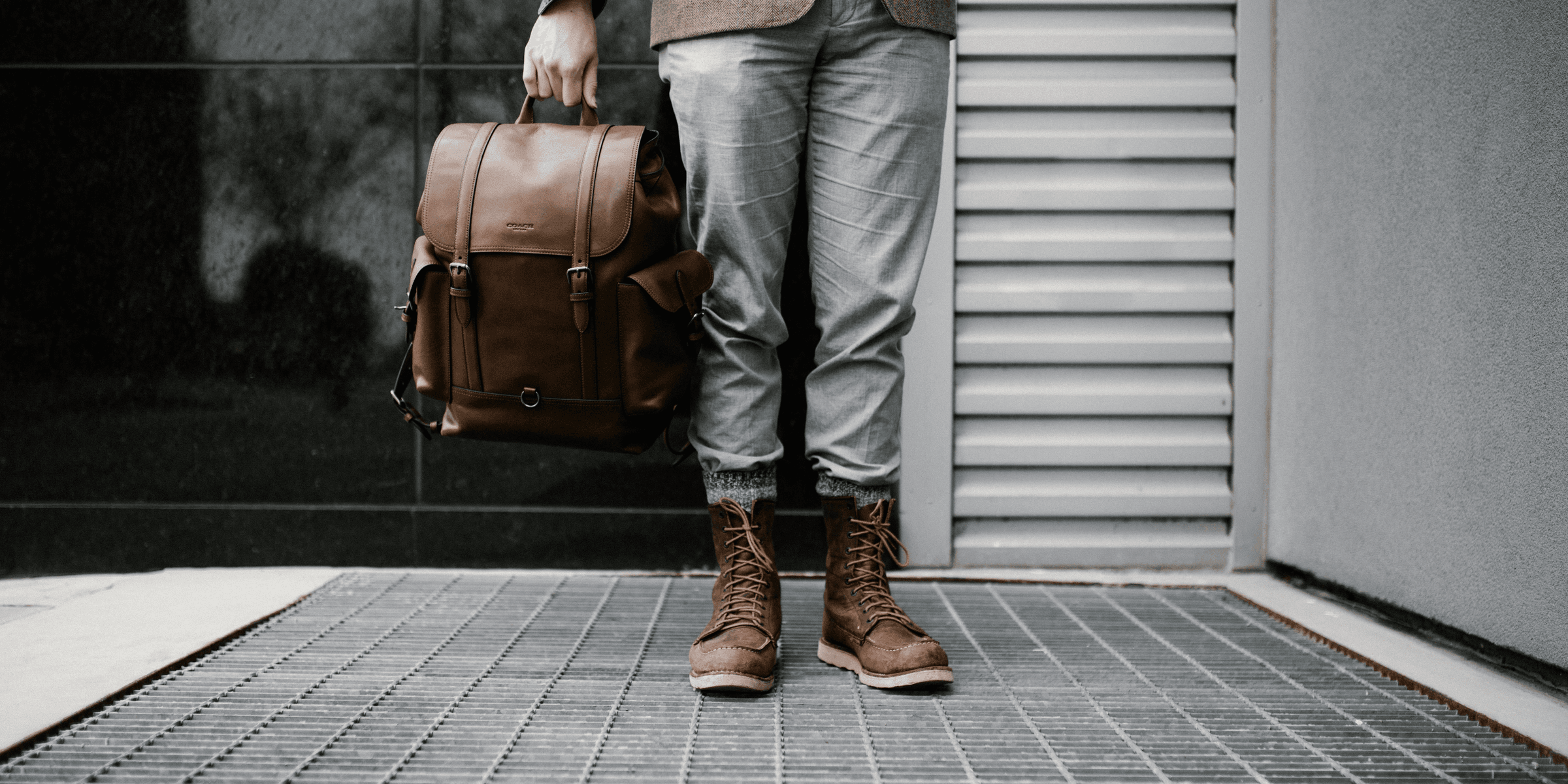 person holding brown leather bag