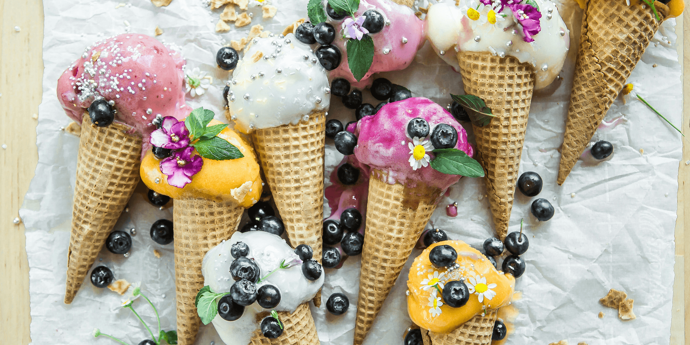 coned ice cream with blueberries and flowers.