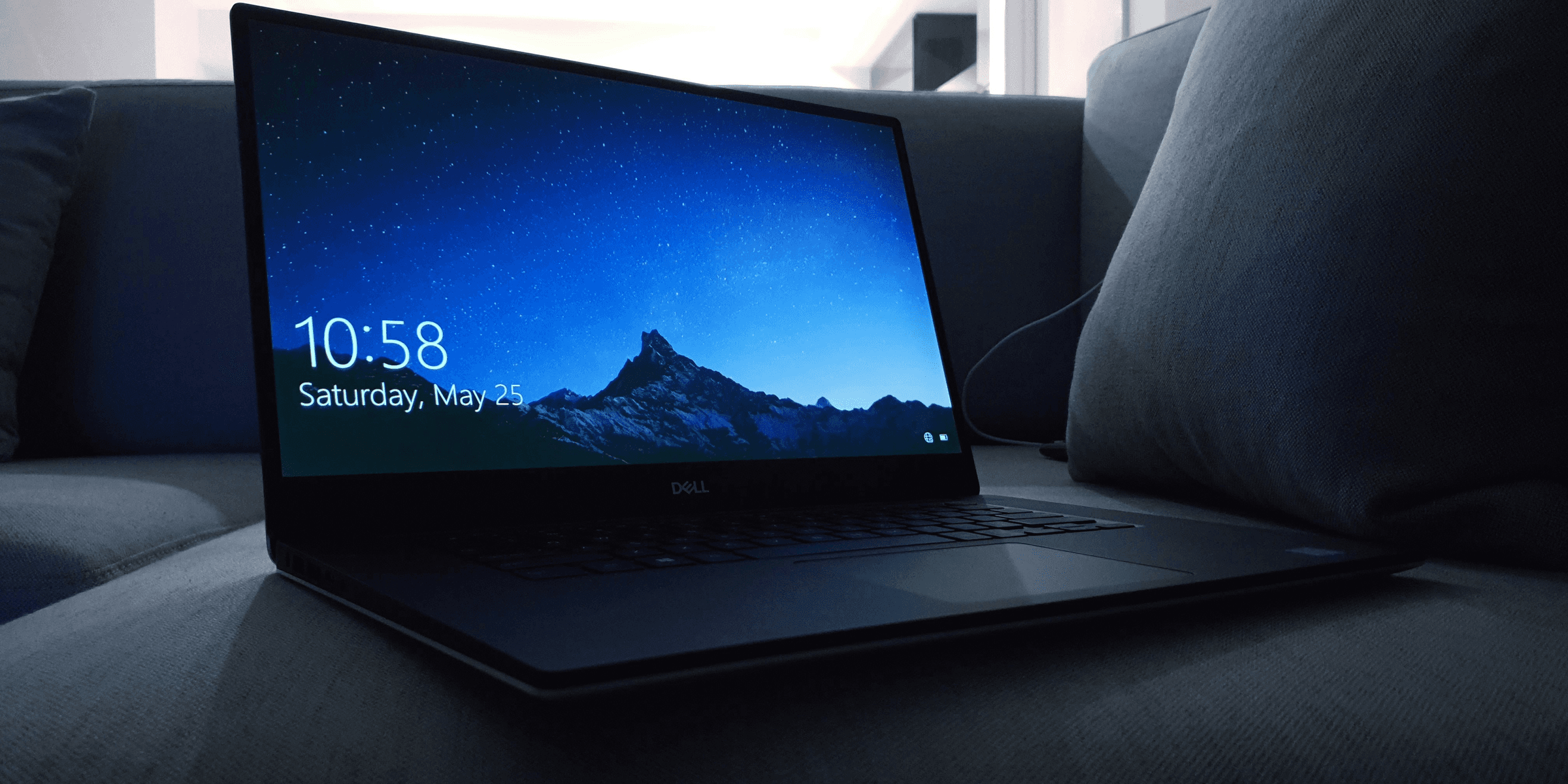 black Dell laptop on sofa.
