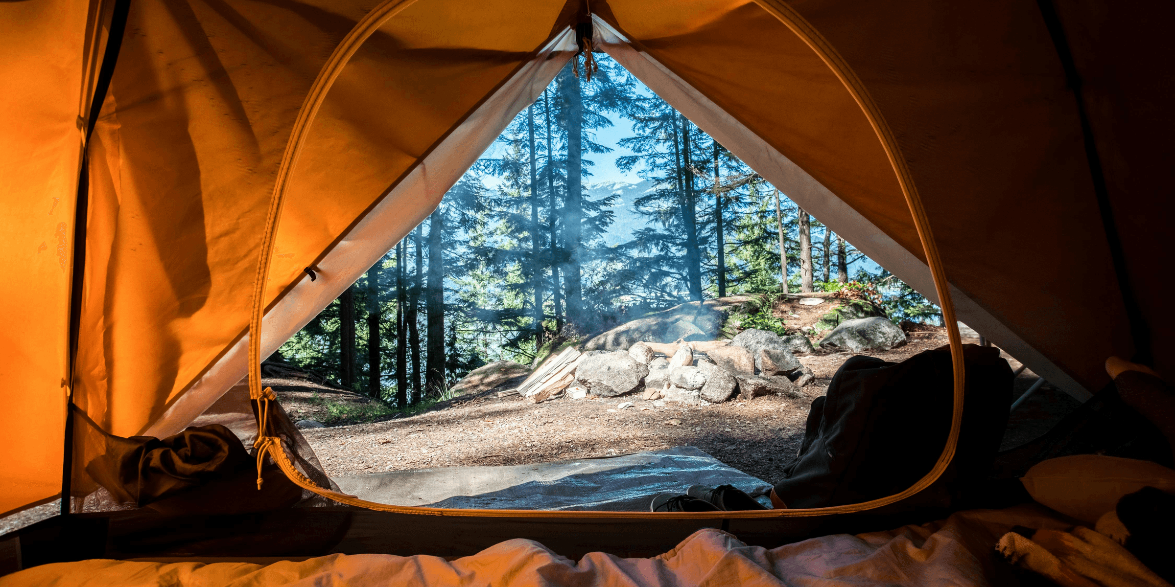 orange camping tent near green trees.