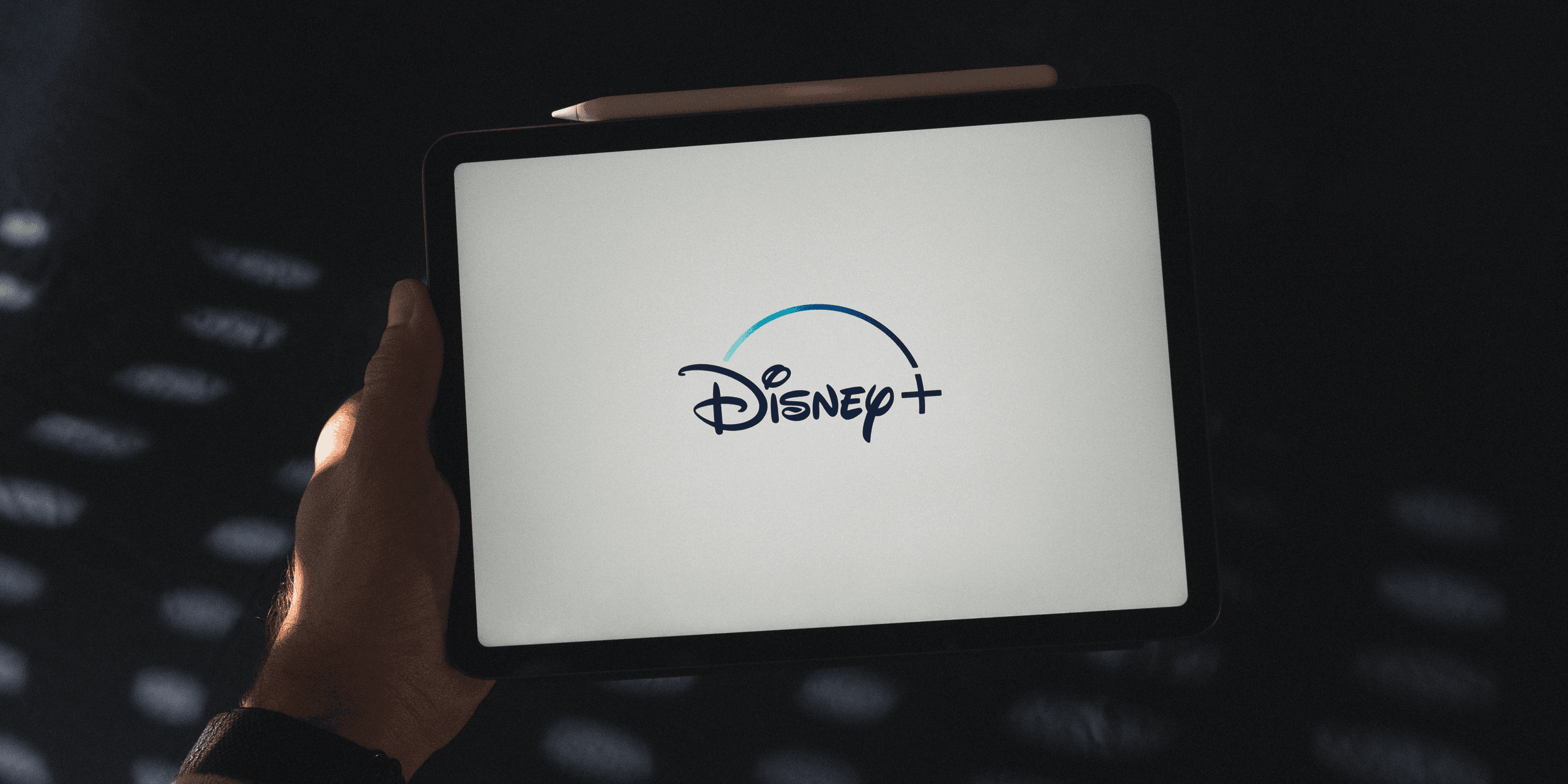 a person holding a tablet with a disney logo on it.