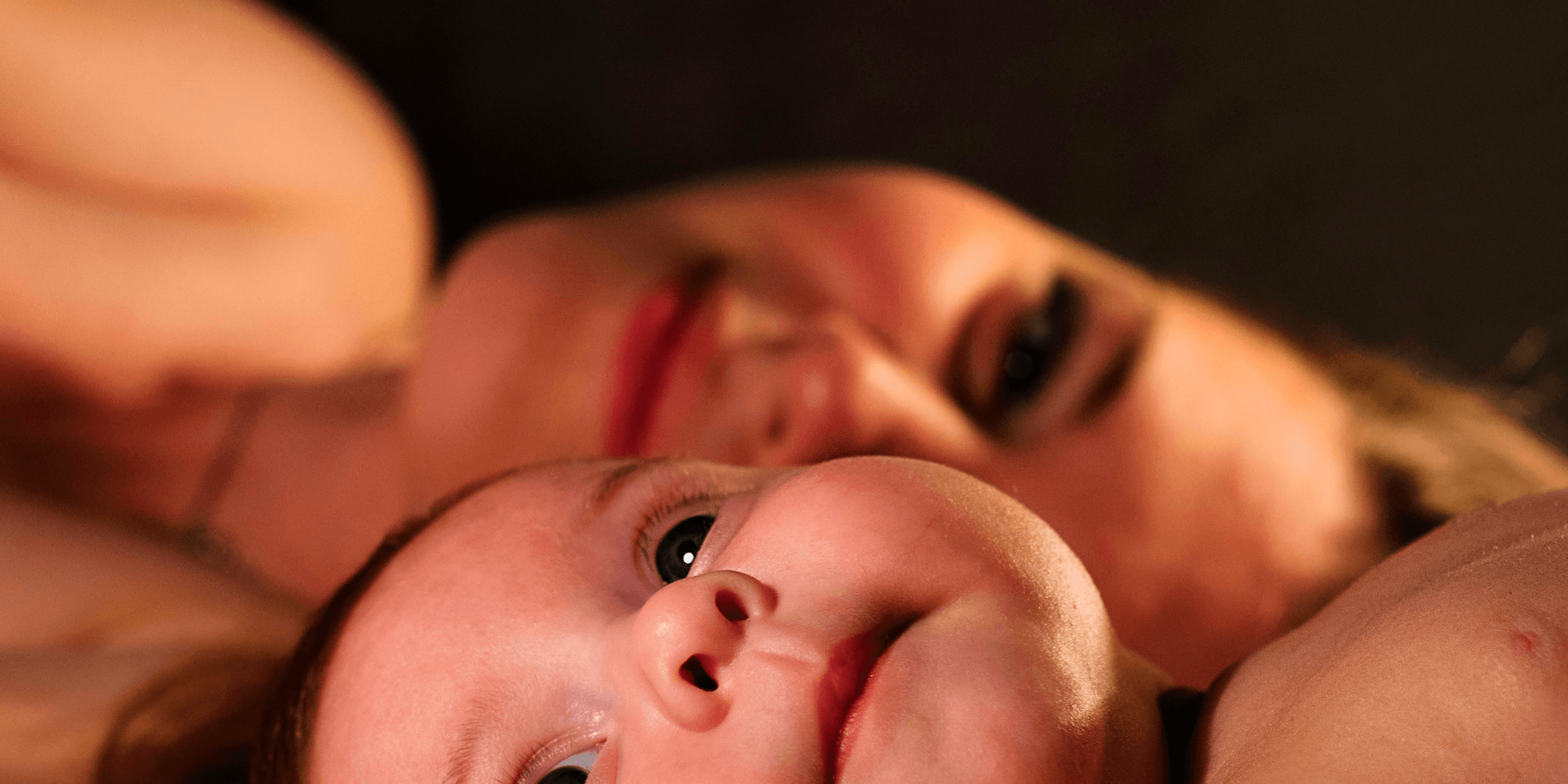 shallow focus photography of baby beside woman.