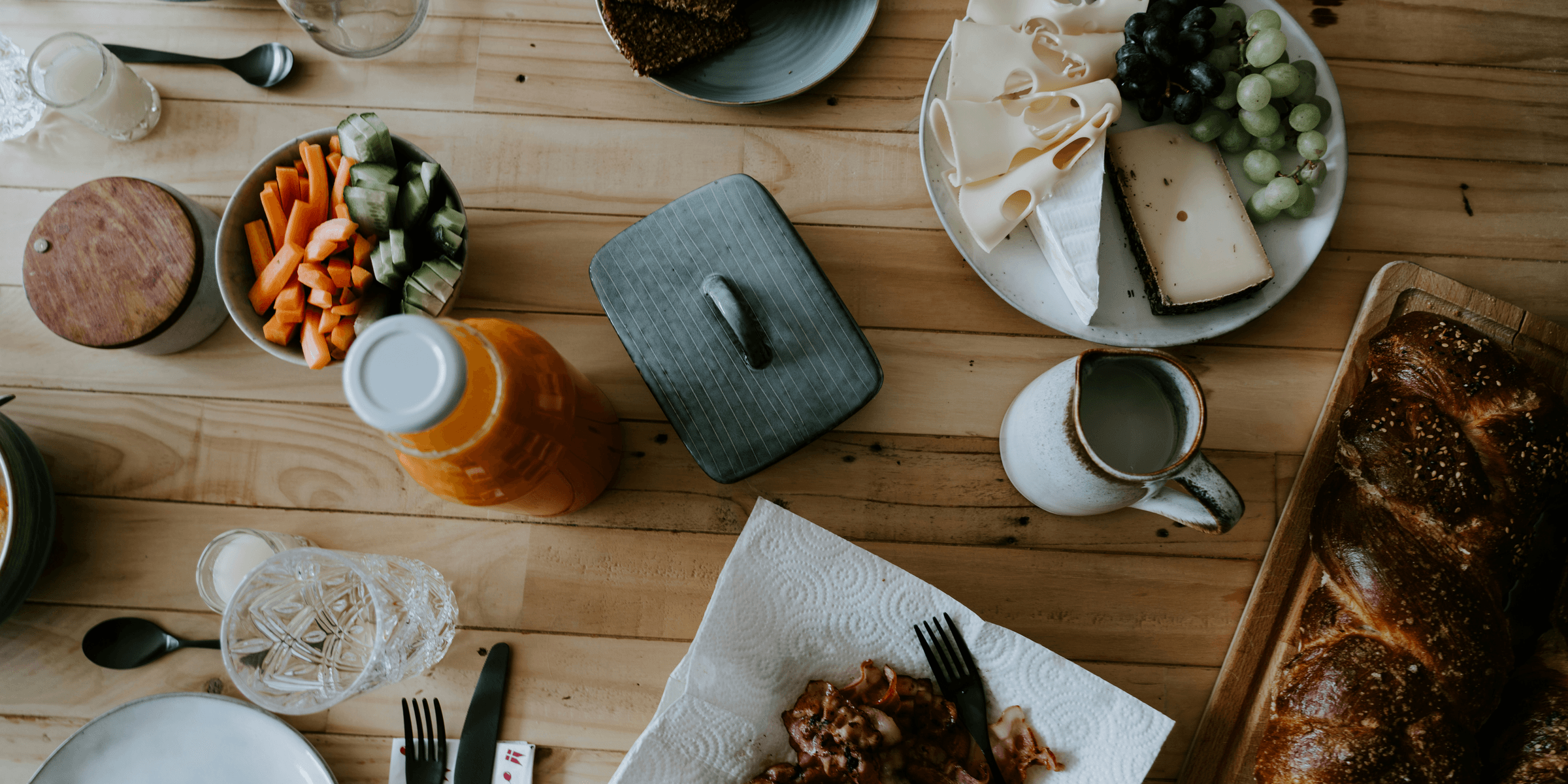 a wooden table topped with plates of food.