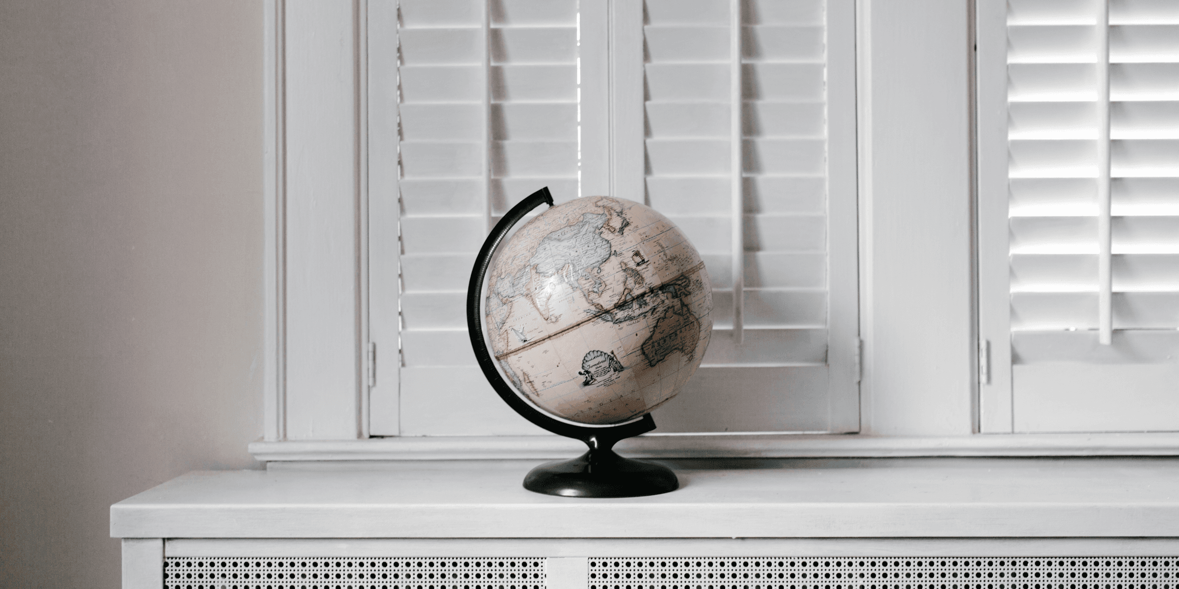 beige desk globe on white desk.