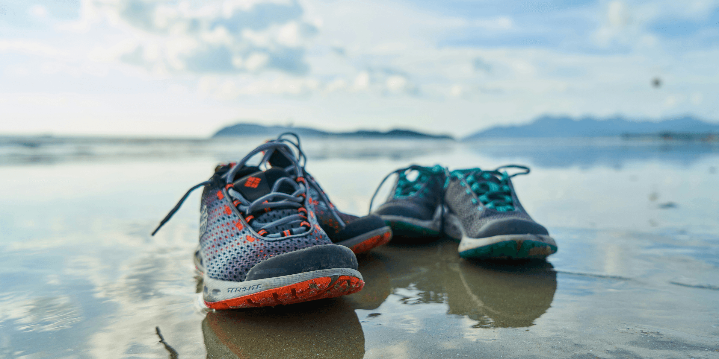 blue and black nike athletic shoes on brown sand during daytime.