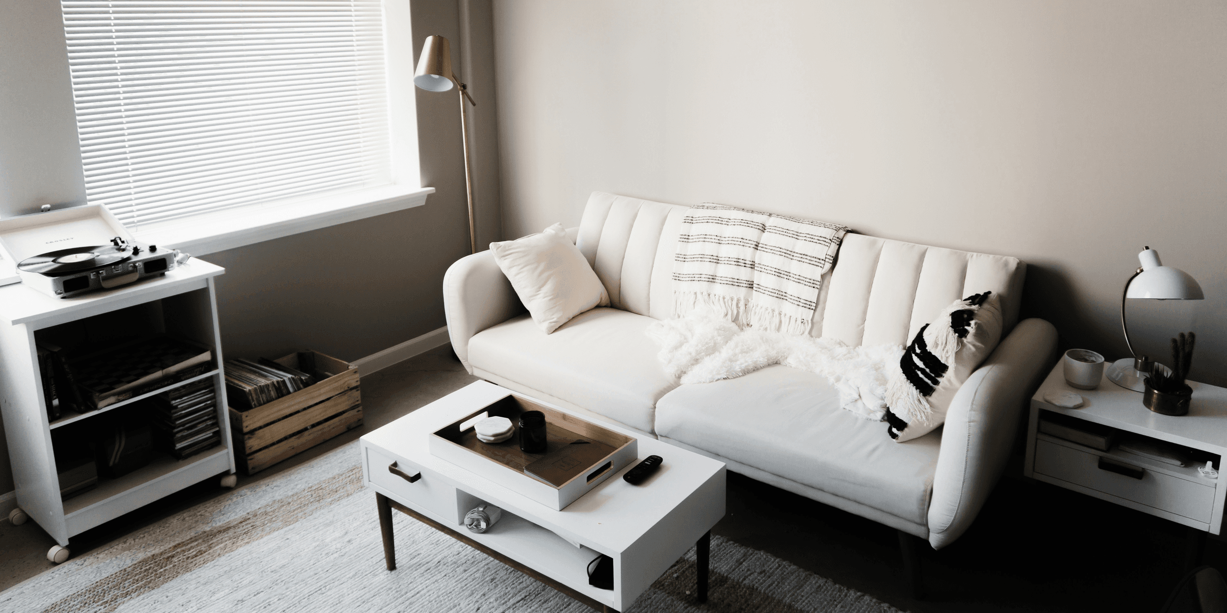 white couch in front of white wooden table.