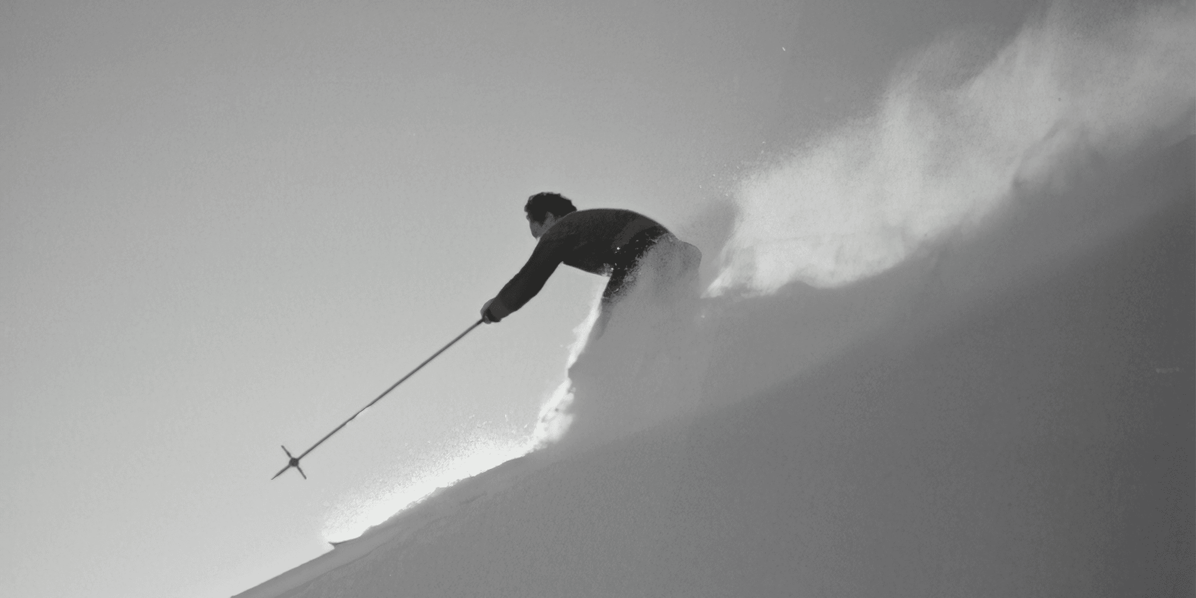 grayscale photography of man skiing on snow