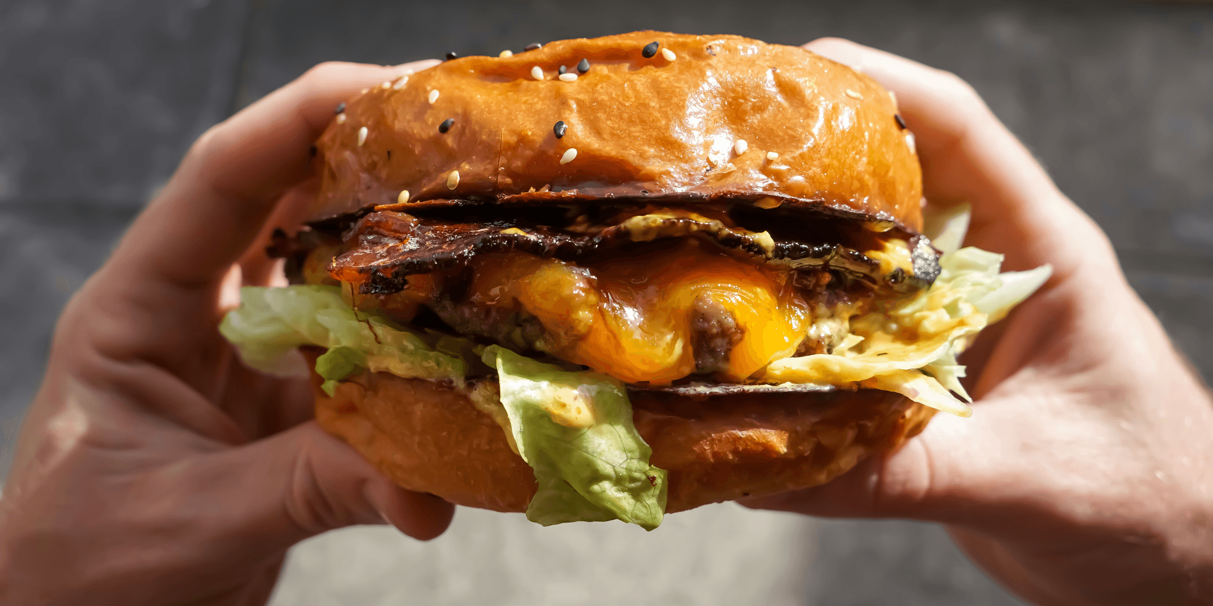 person holding cheese burger.