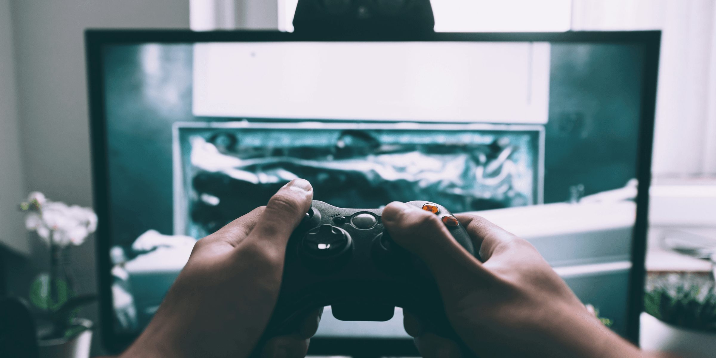 person holding game controller in-front of television.