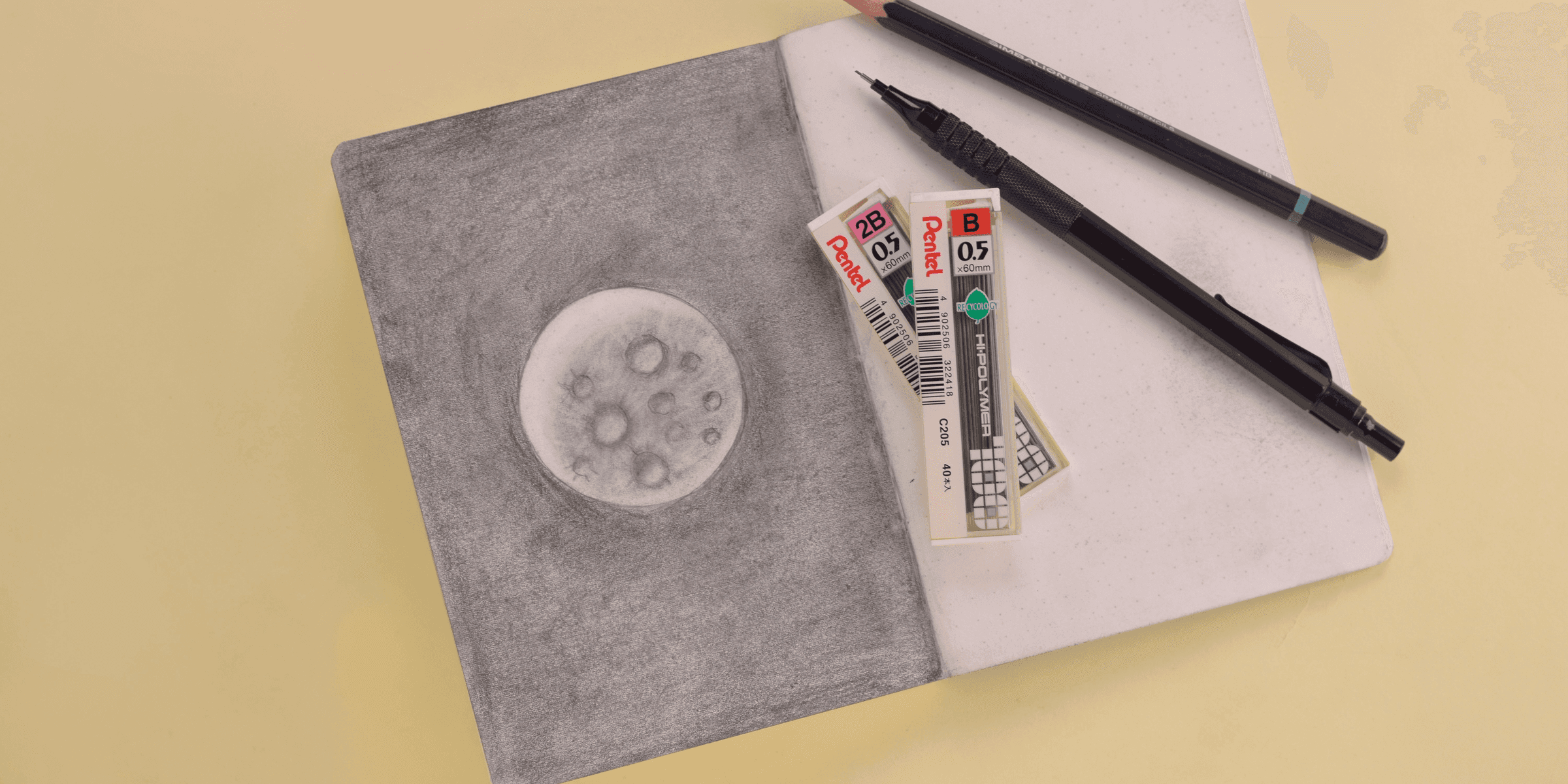 two pencils and two markers on a piece of paper.