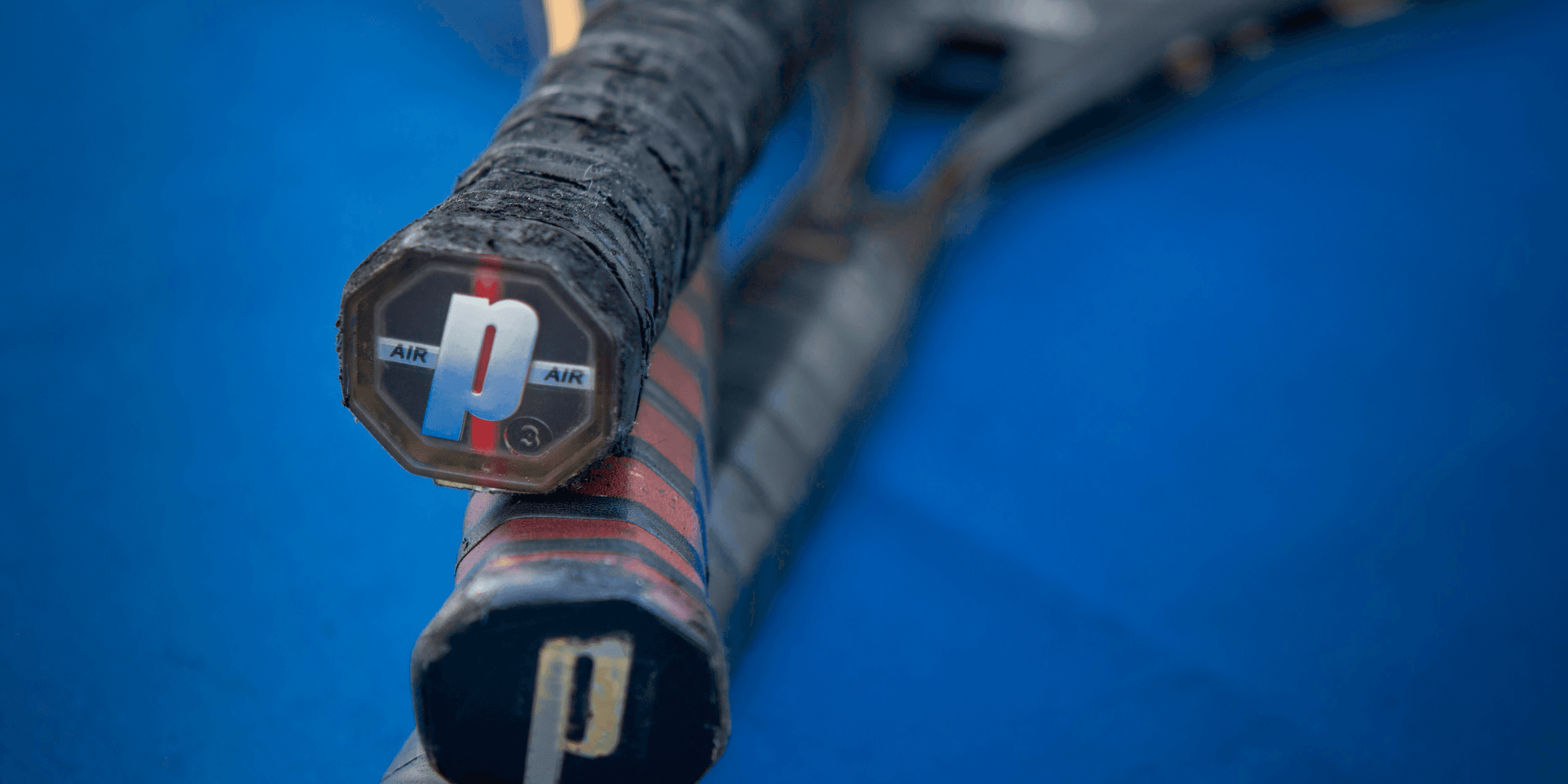 a close up of a tennis racket on a blue surface