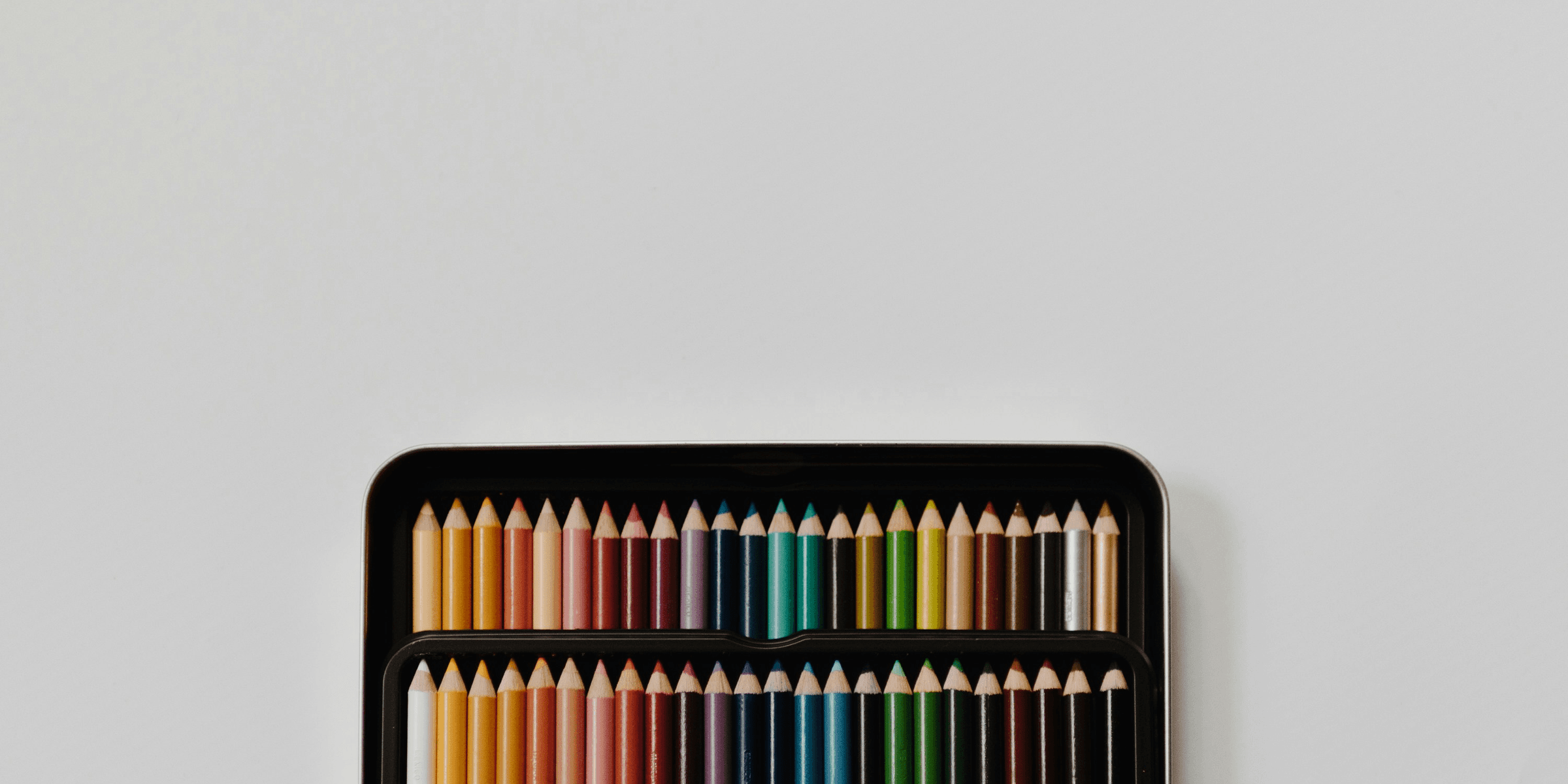 assorted-color pencil set with case on white surface.