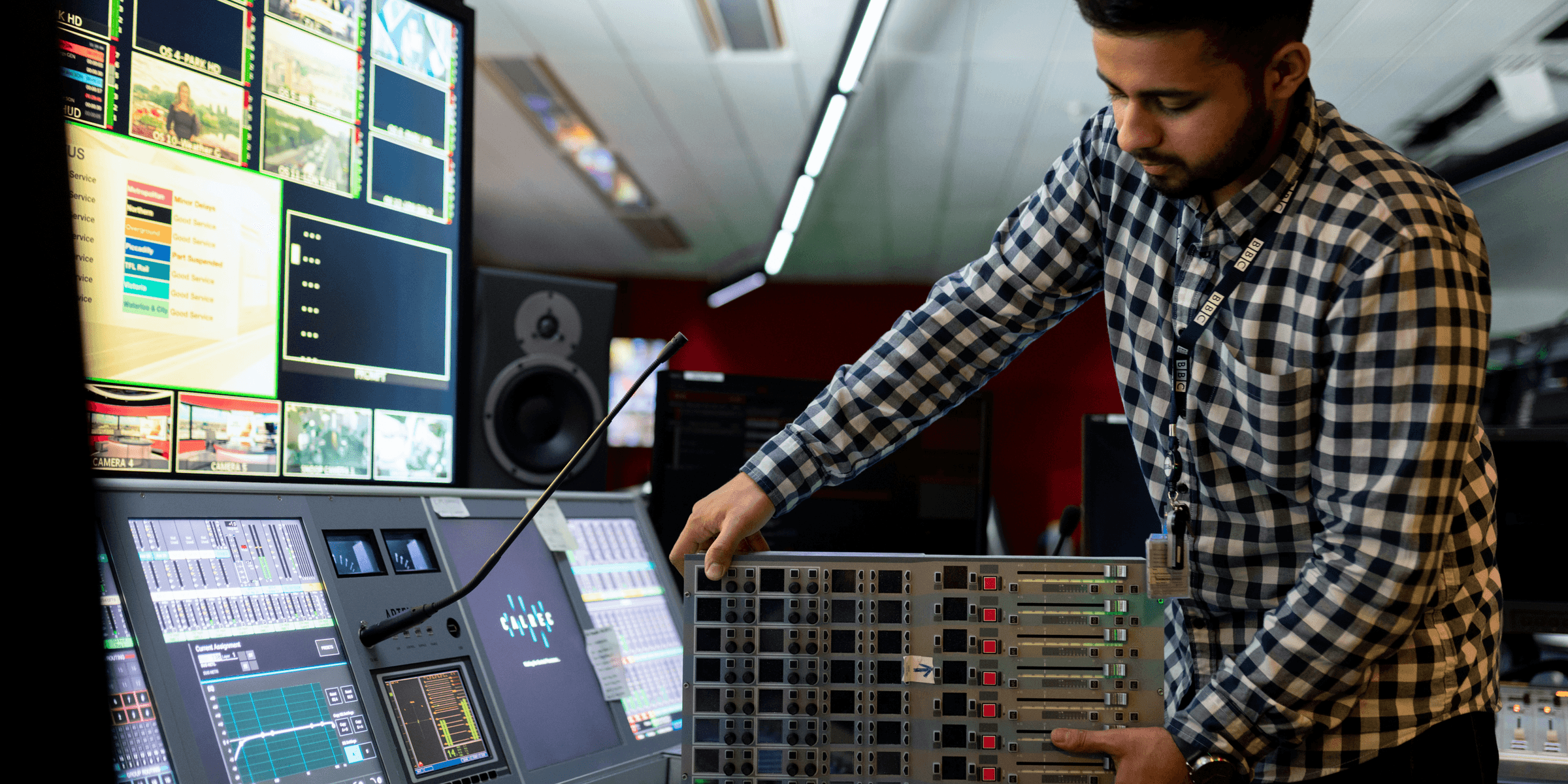 man in black and white checkered dress shirt playing dj controller.