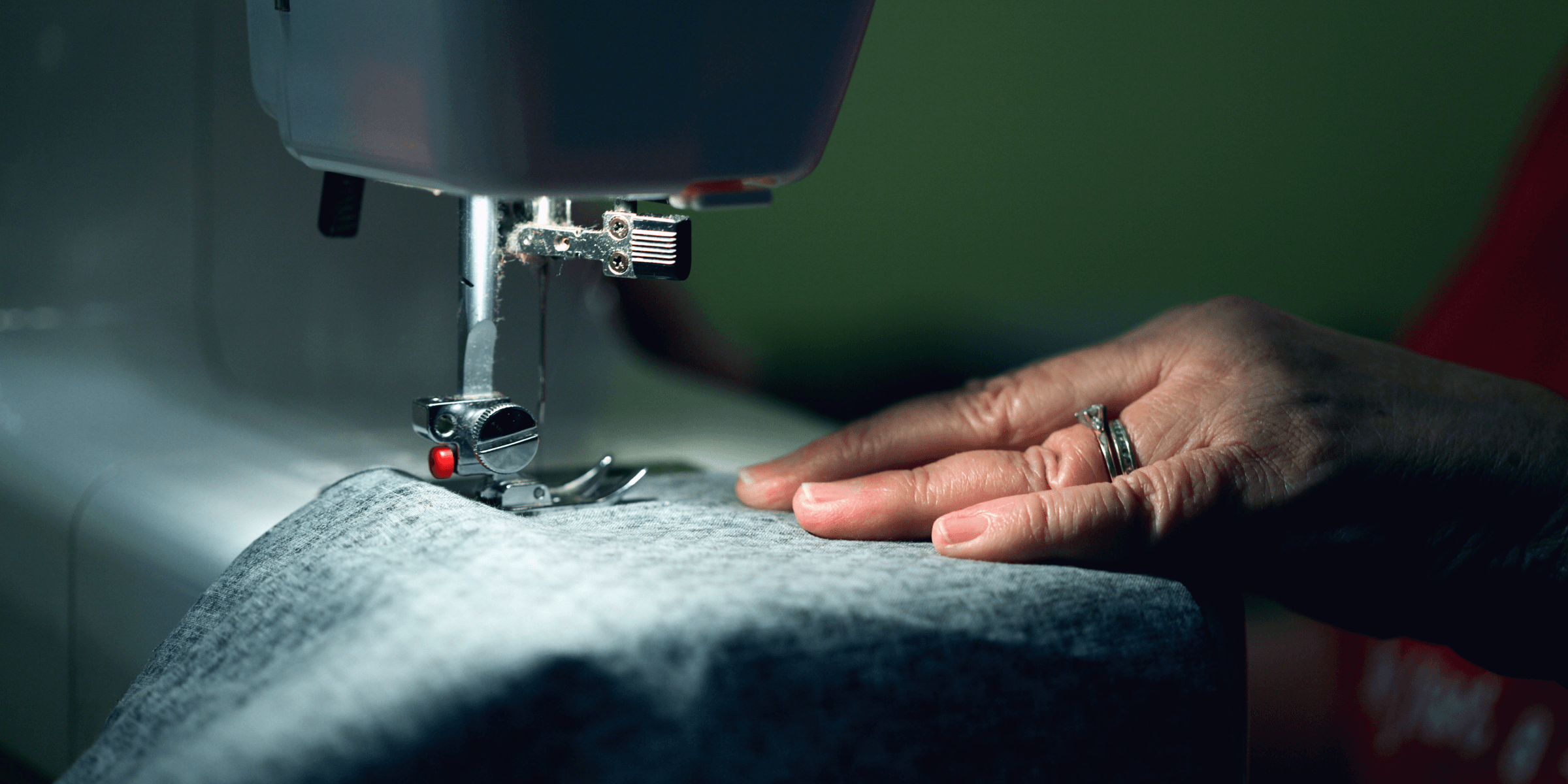 person in gray shirt sewing.