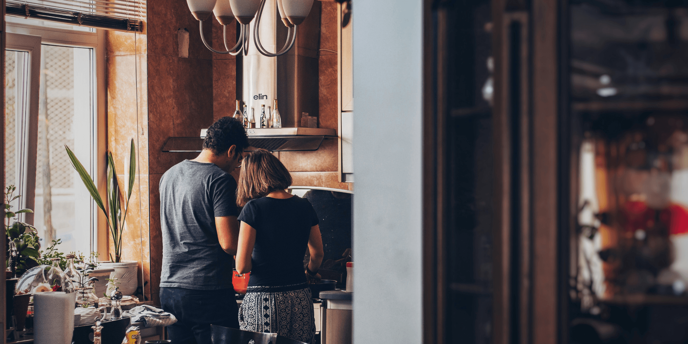 man and woman standing in front of gas range.