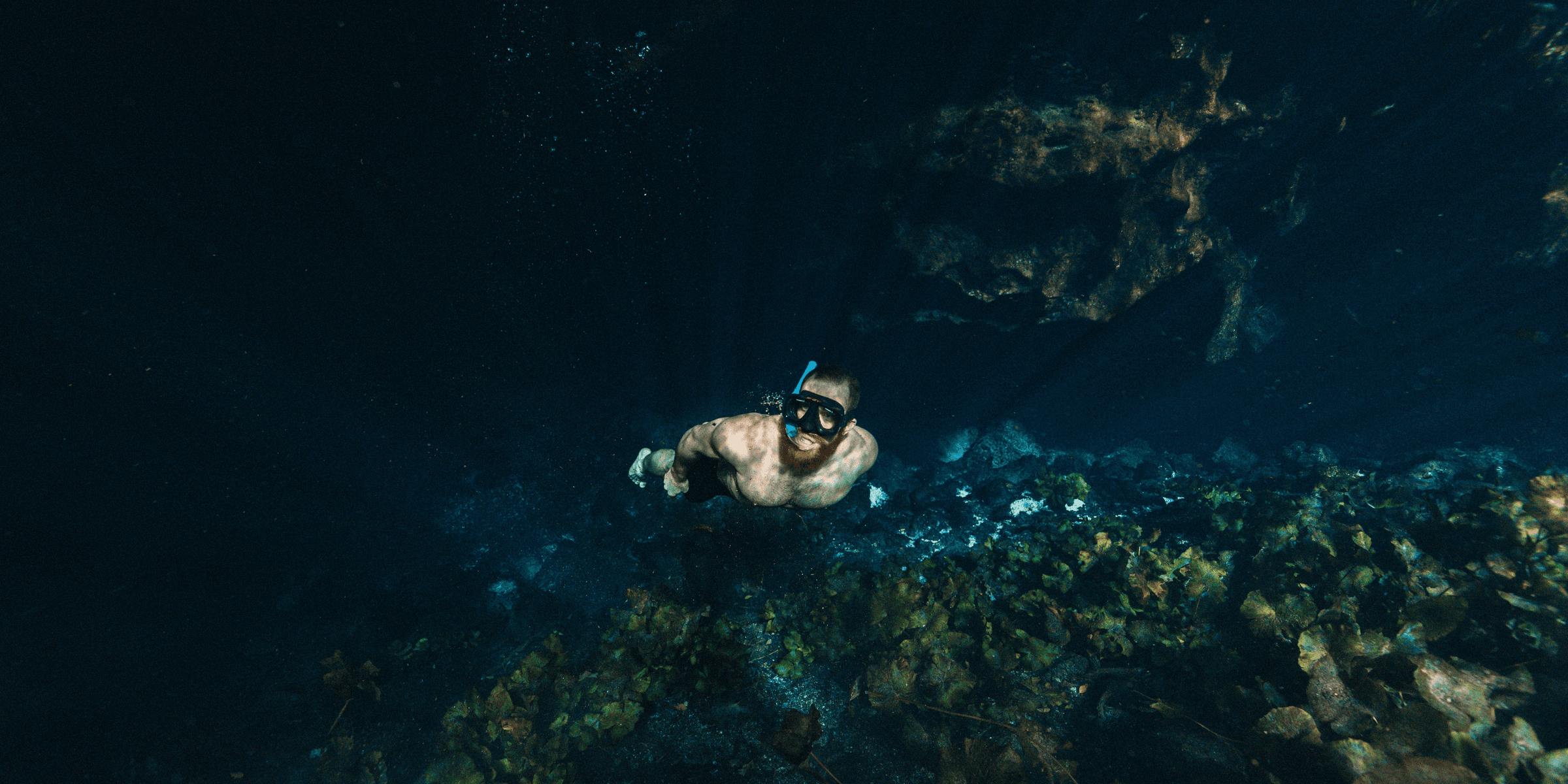 man free diving in clear water.
