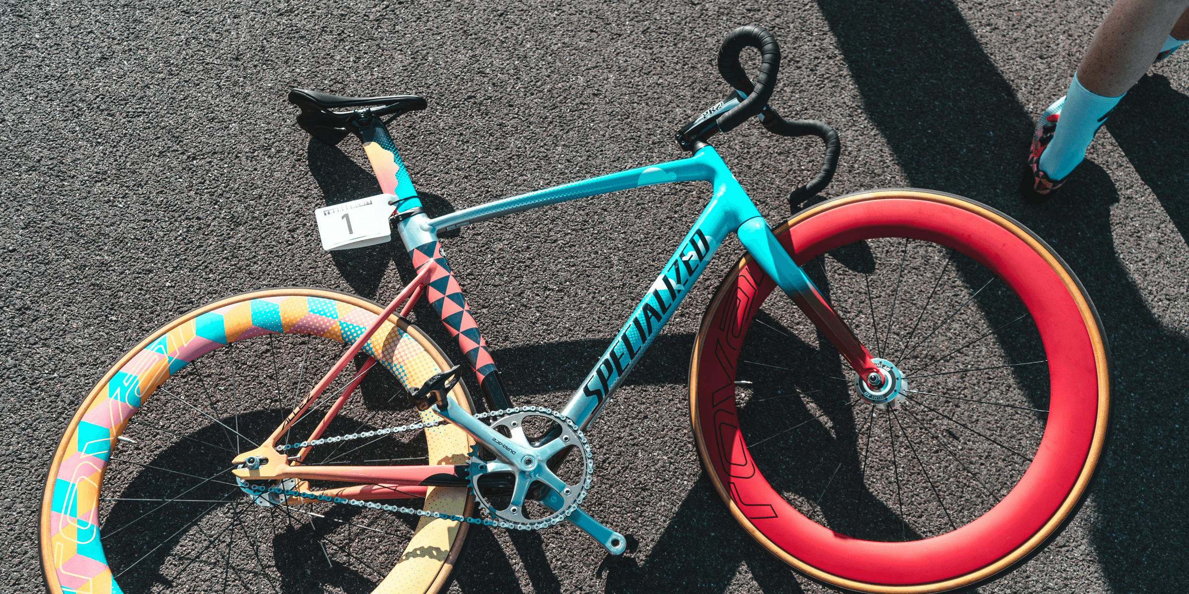 blue and red Specialized fixie bike on grey surface.