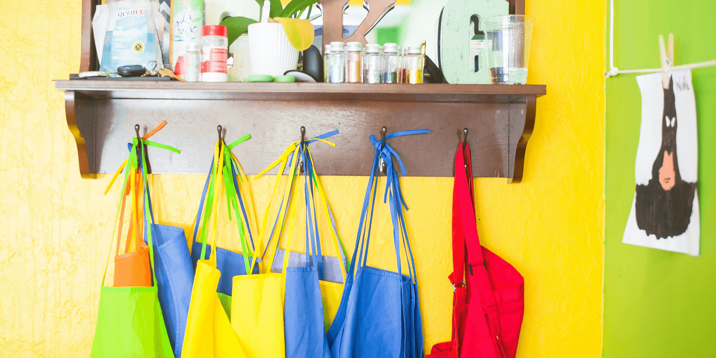 assorted-color bag lot hanging on brown wooden wall rack.