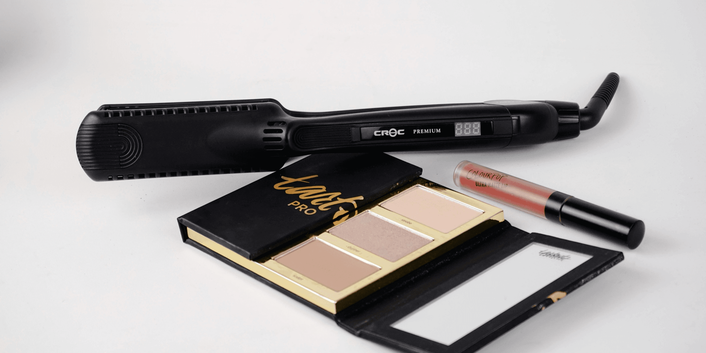 selective focus photography of hair flat iron and Tarte Pro eyeshadow palette.