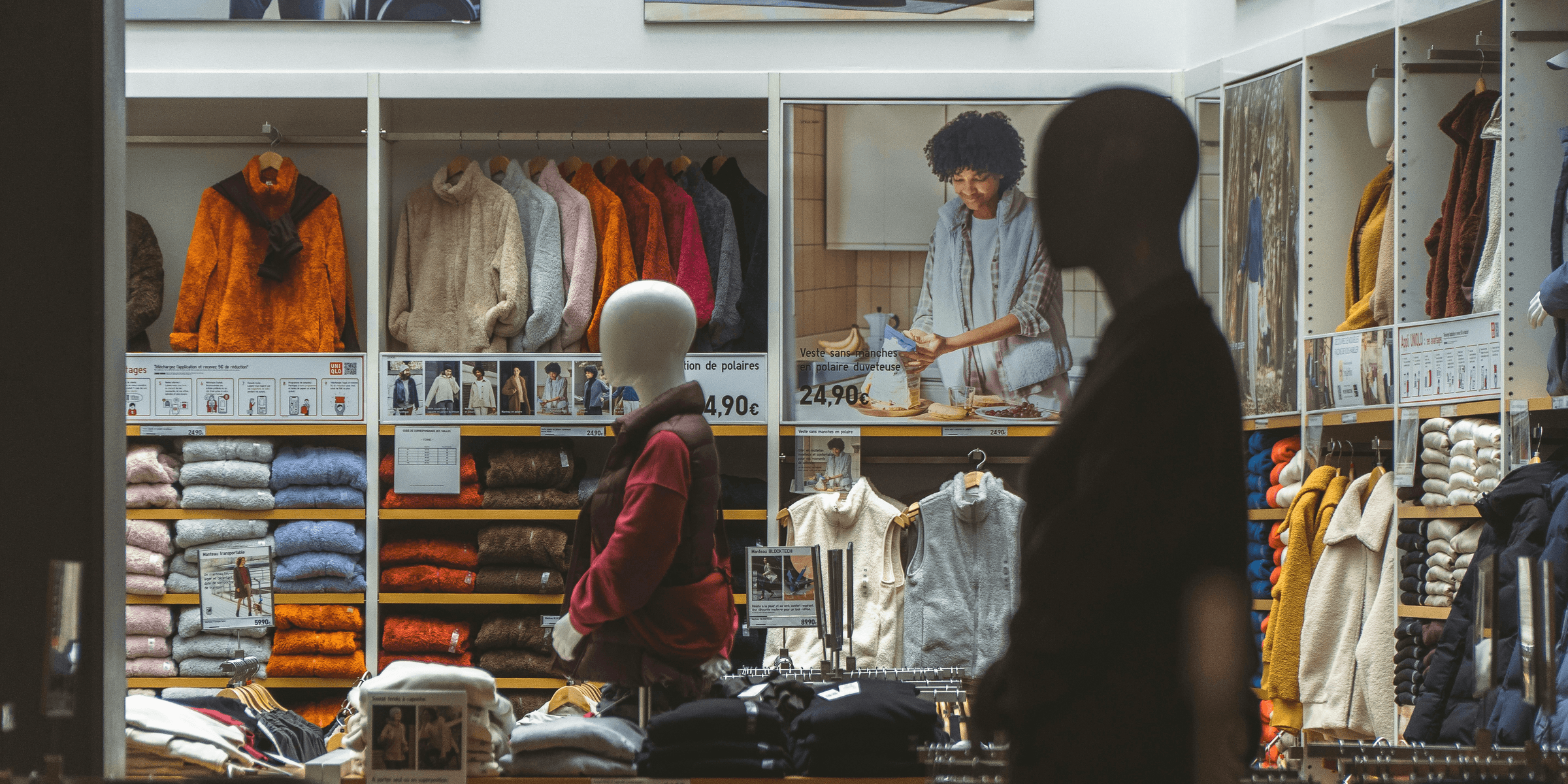 a man standing in front of a store filled with clothing