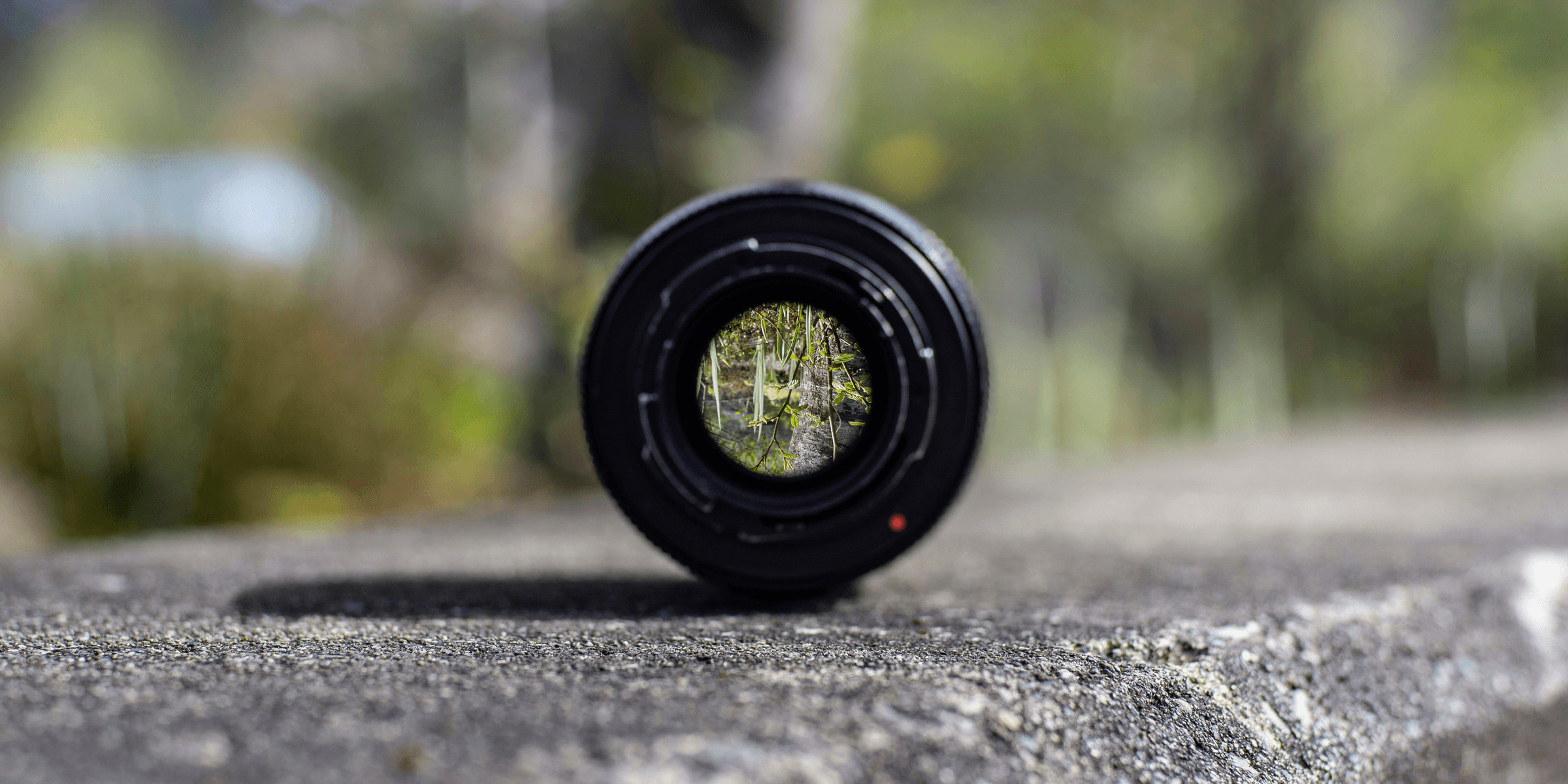 black DSLR camera lens on concrete surface.