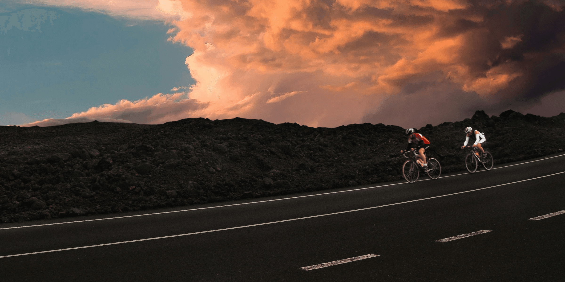 two cyclist on road during golden hour