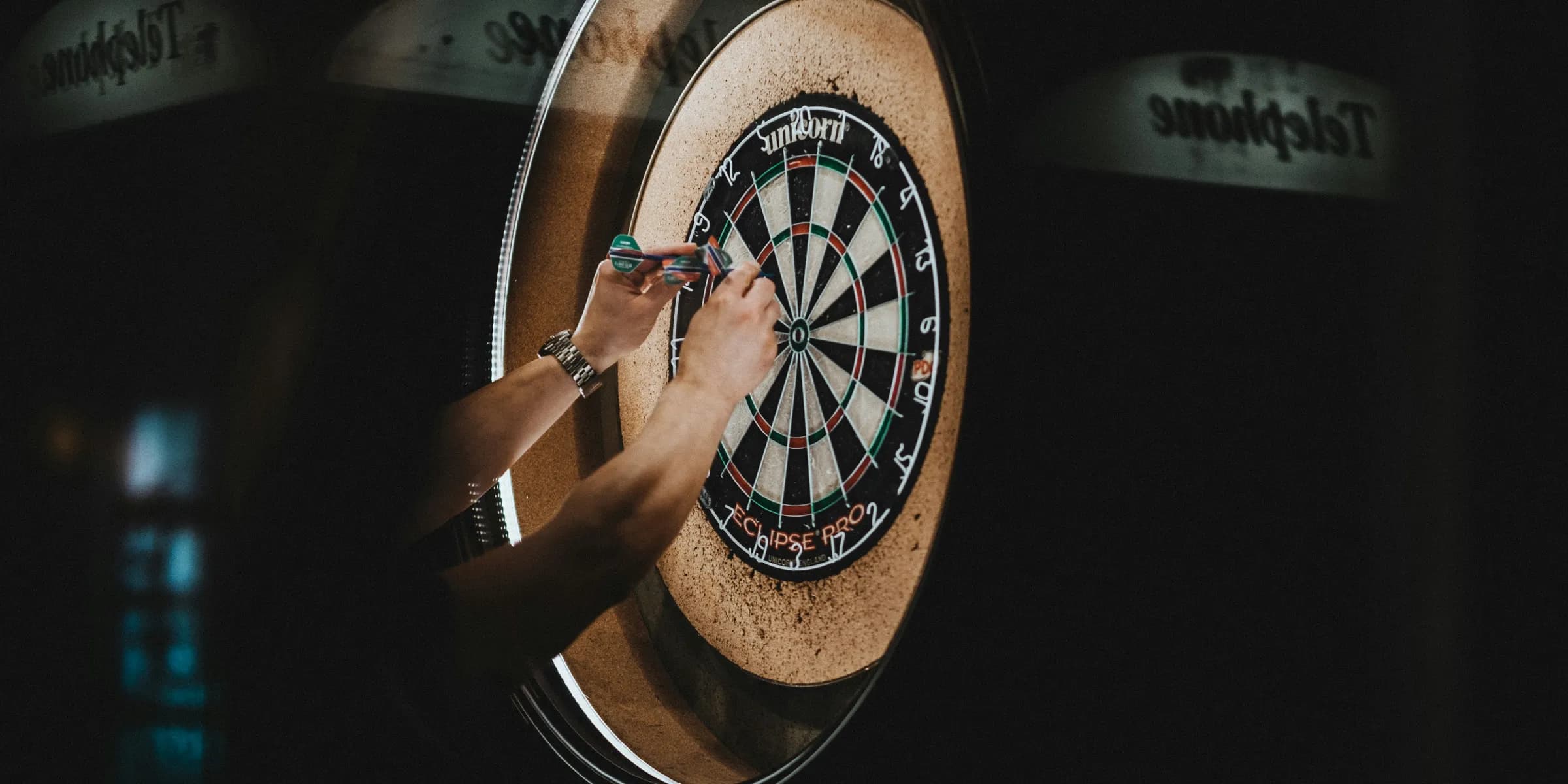person picking dart pins on board