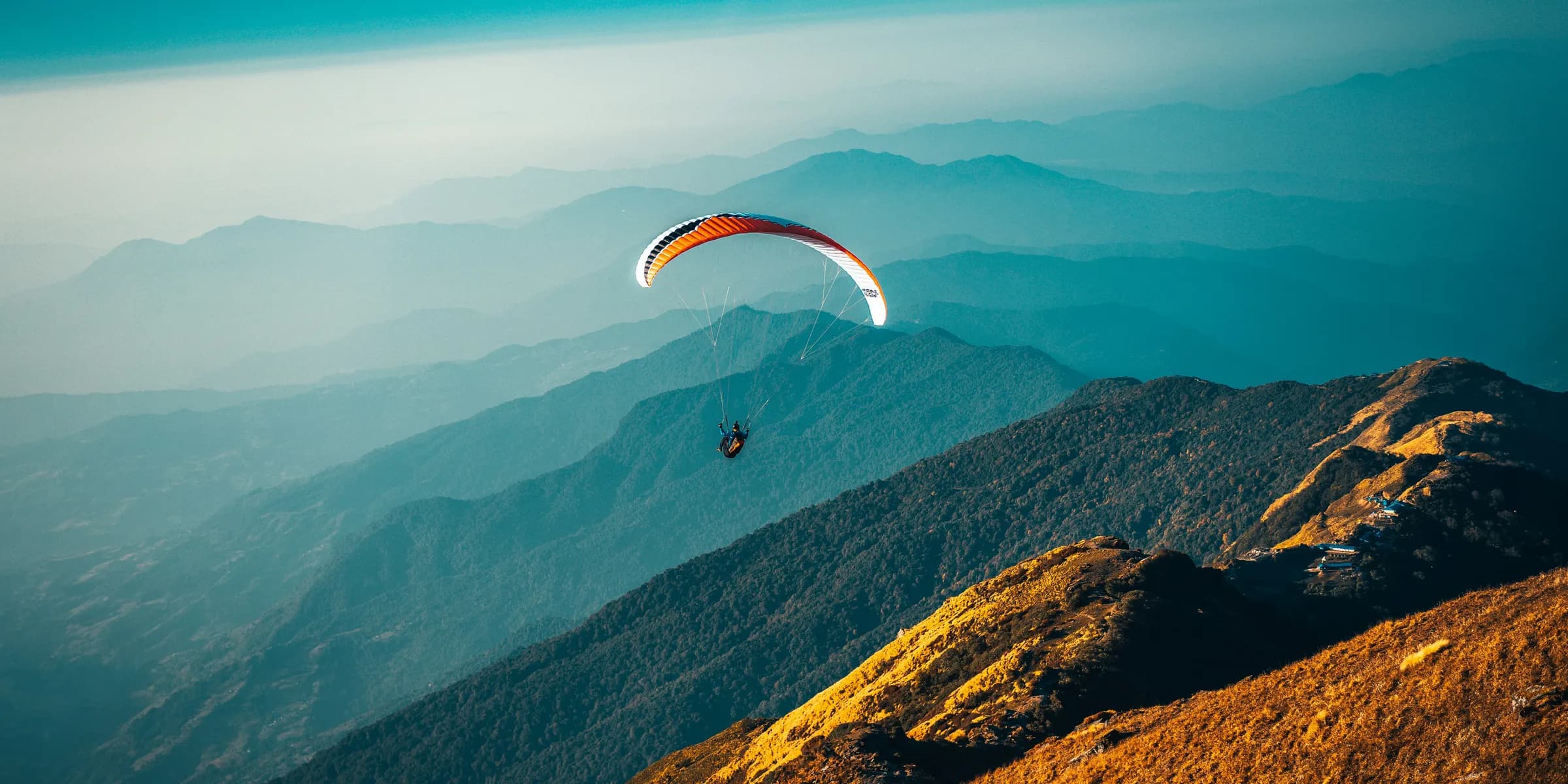 person in parachute over mountains during daytime