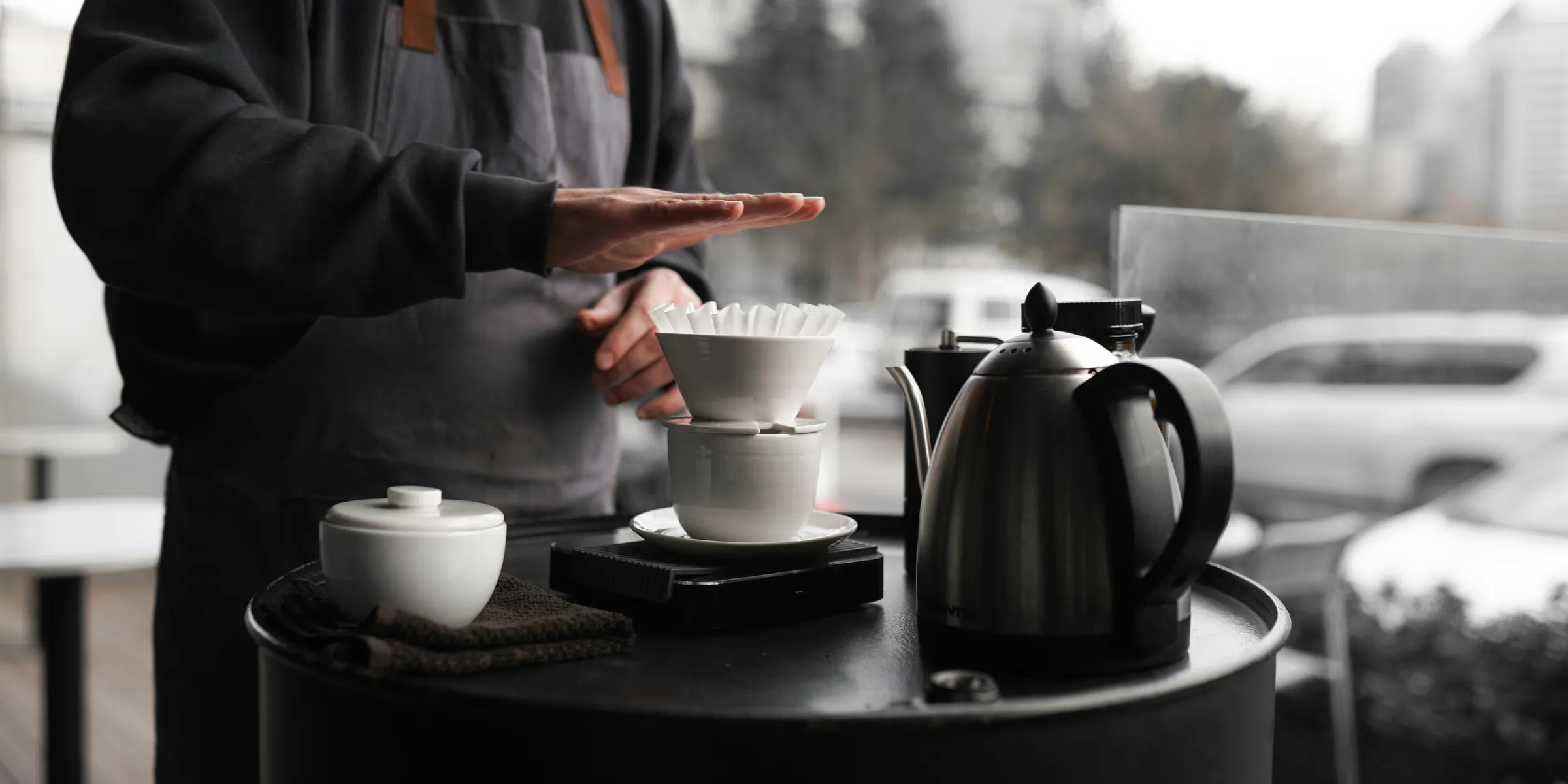 A man standing next to a table with a cup of coffee on it