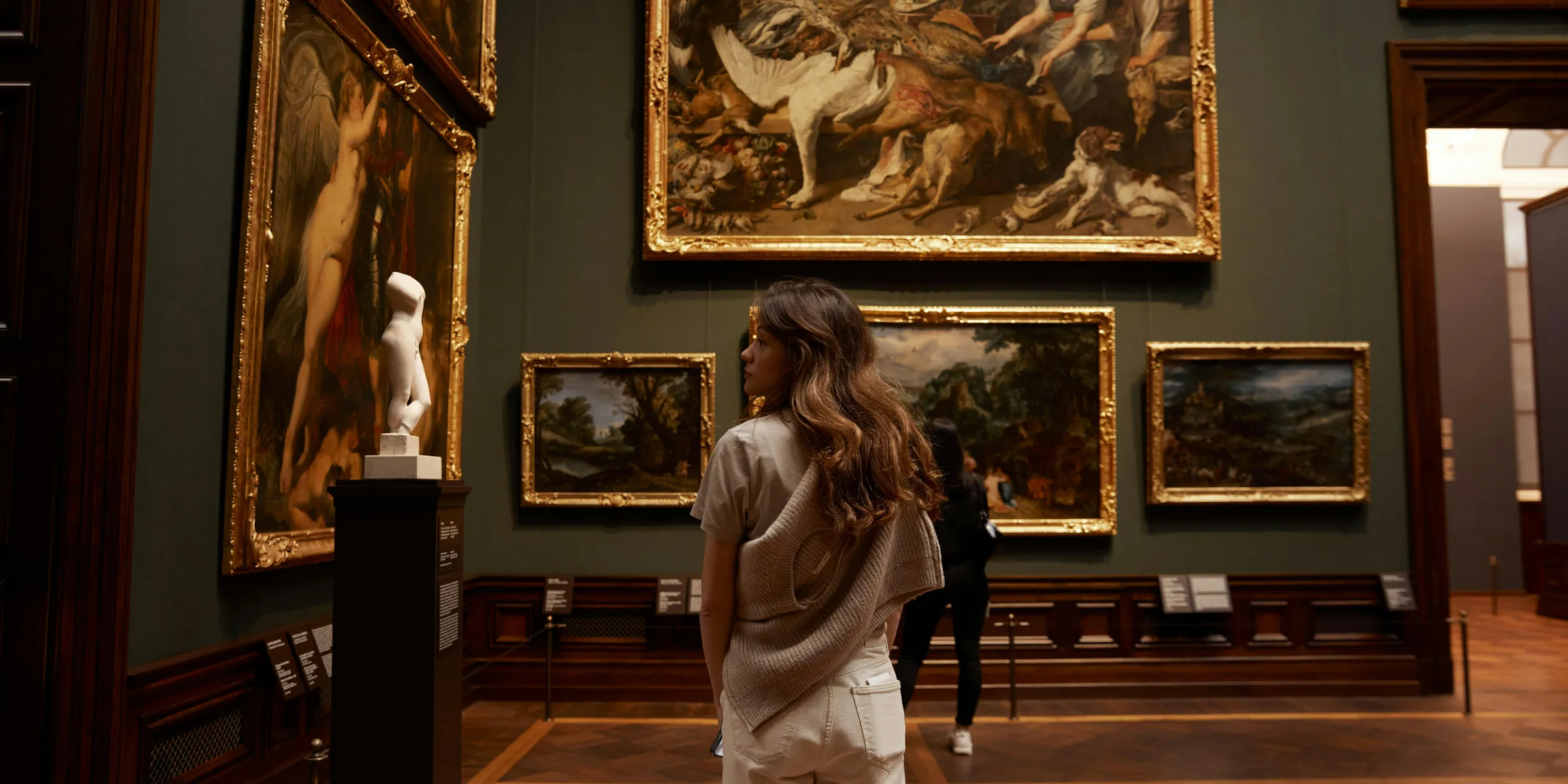 a woman looking at paintings in a museum