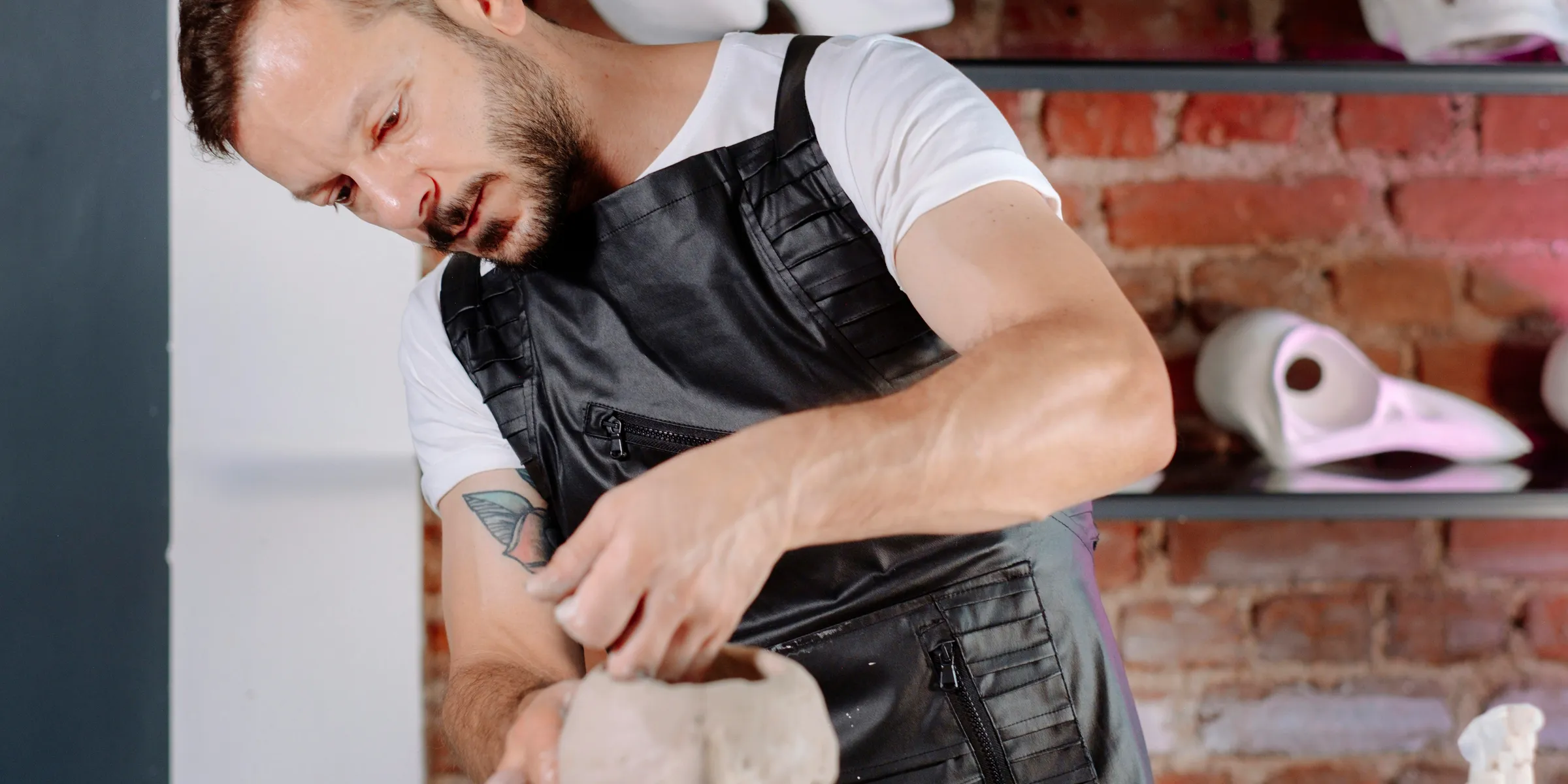 A man in an apron is making a doughnut