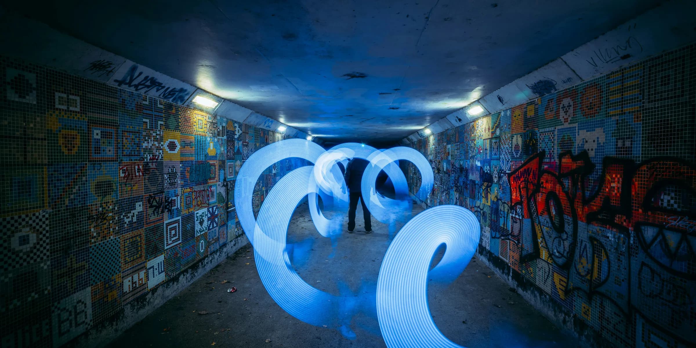 a couple of people standing in a room with graffiti on the walls