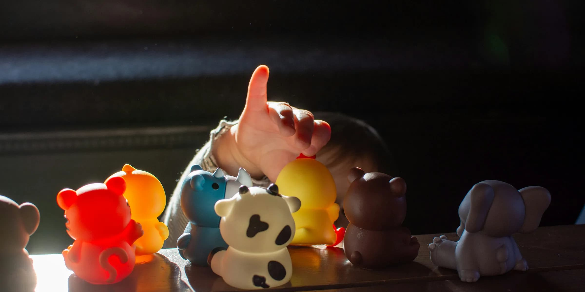 a baby reaching for a toy on a table