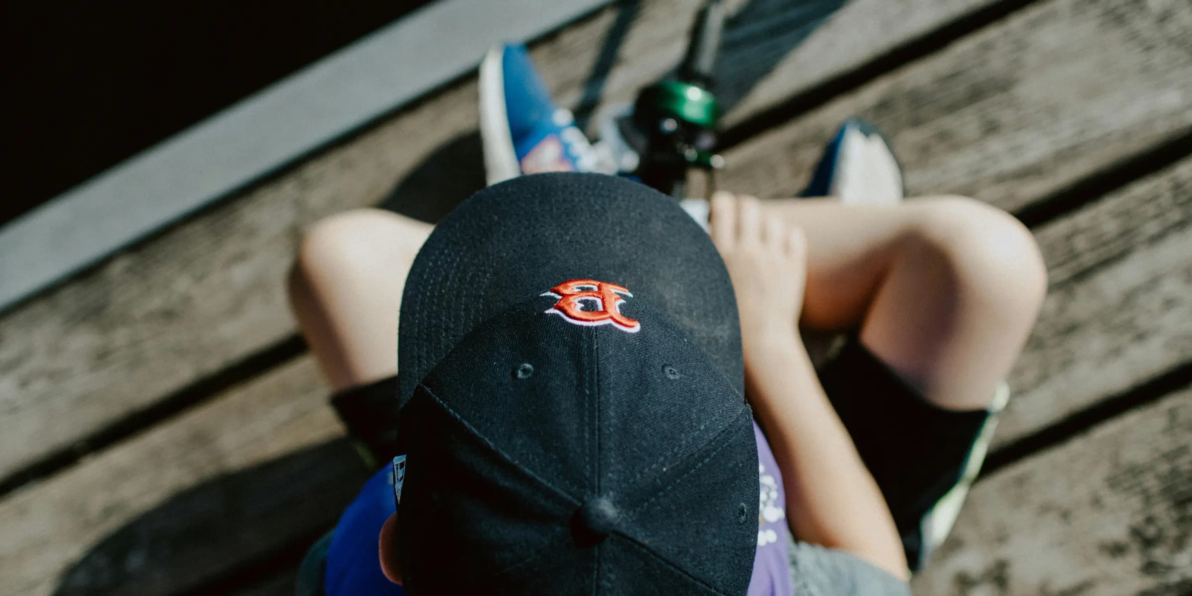 person wearing black cap holding fishing rod