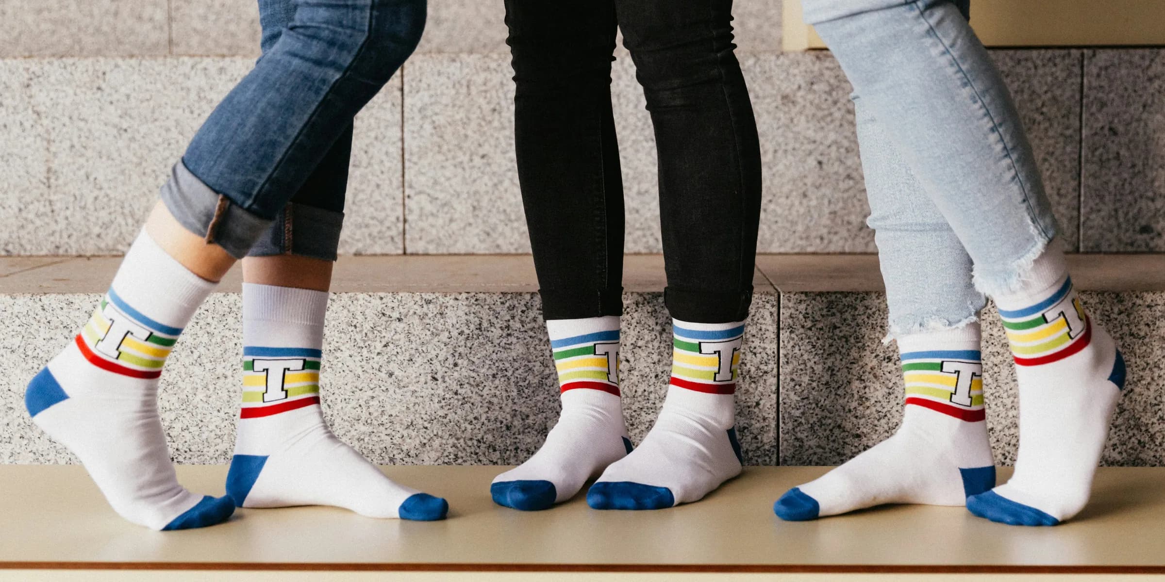 person in blue denim jeans and white blue and yellow socks