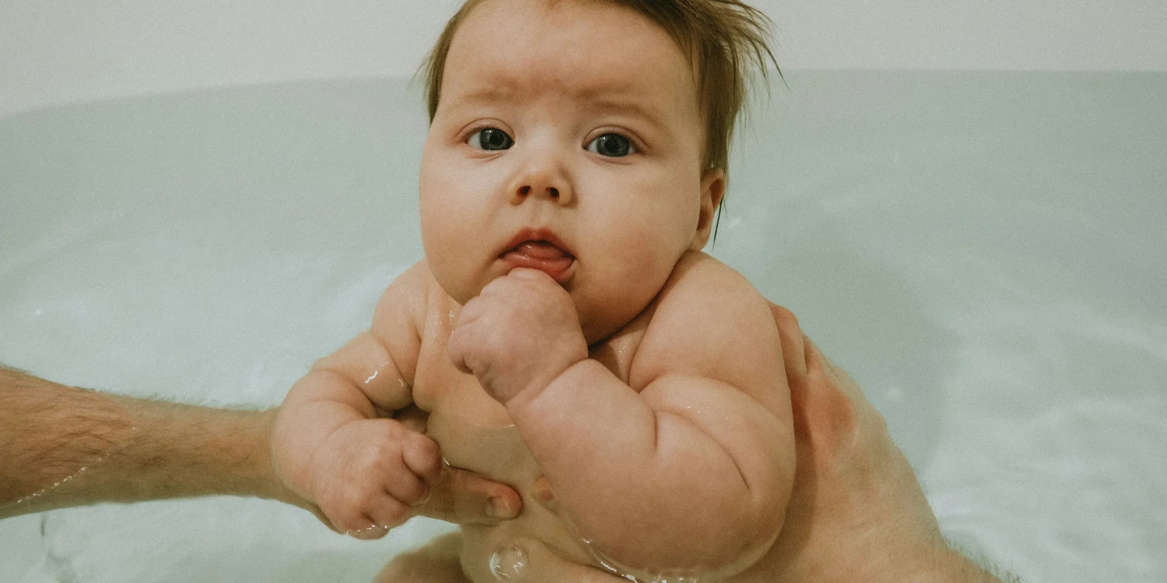 a man holding a baby in a bathtub