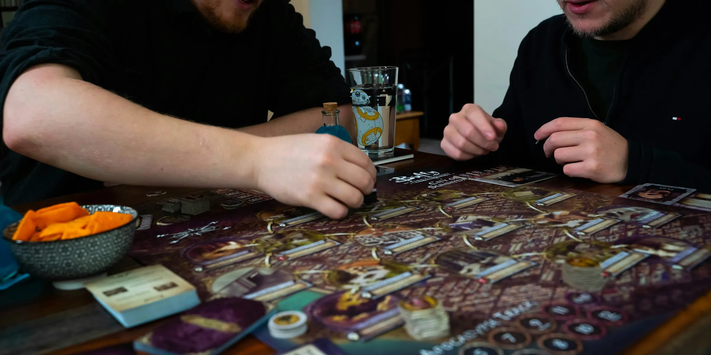 two men sitting at a table playing a board game