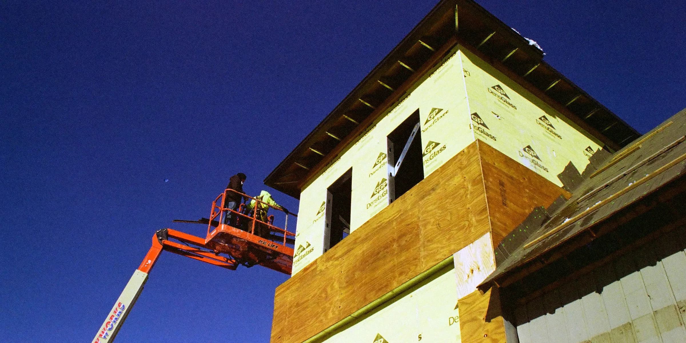 a man on a cherry picker working on a building