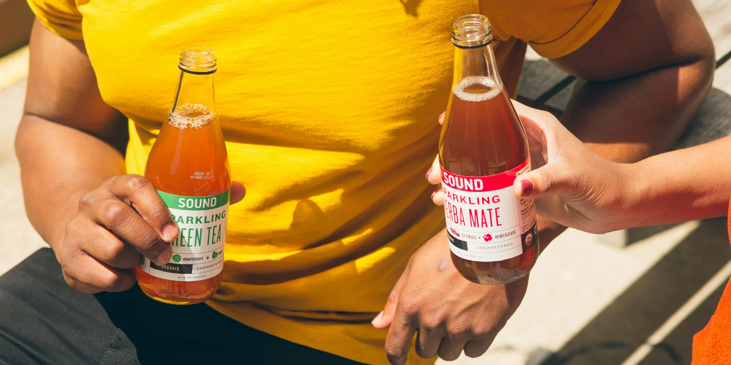 men holding two tea bottles