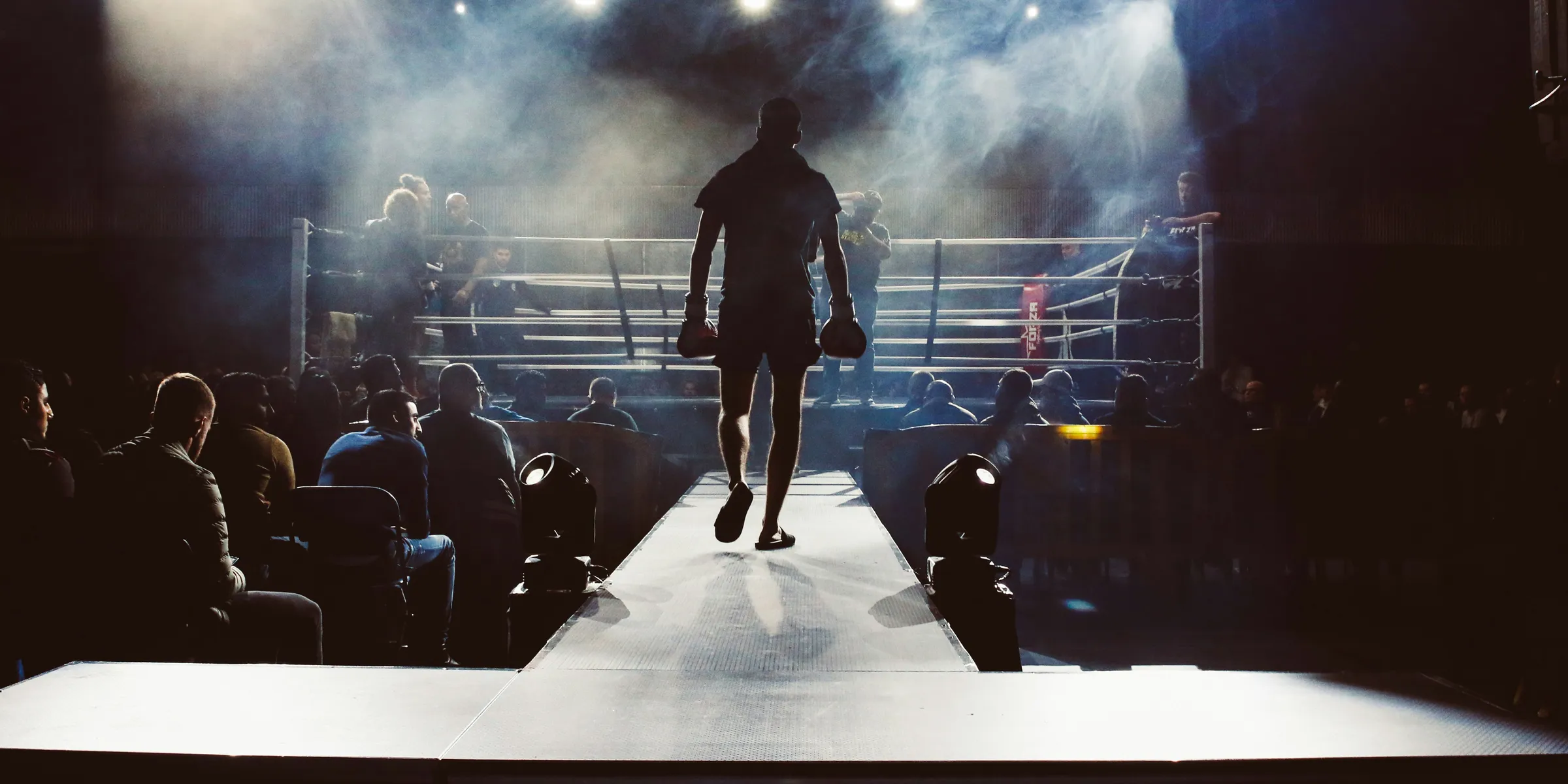 man standing and walking going on boxing ring surrounded with people