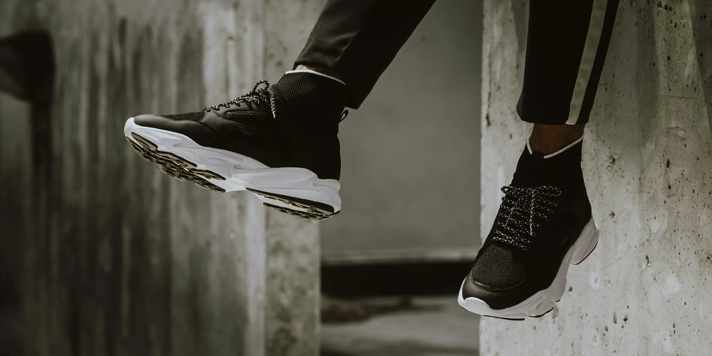 sitting person wearing black-and-white running shoes