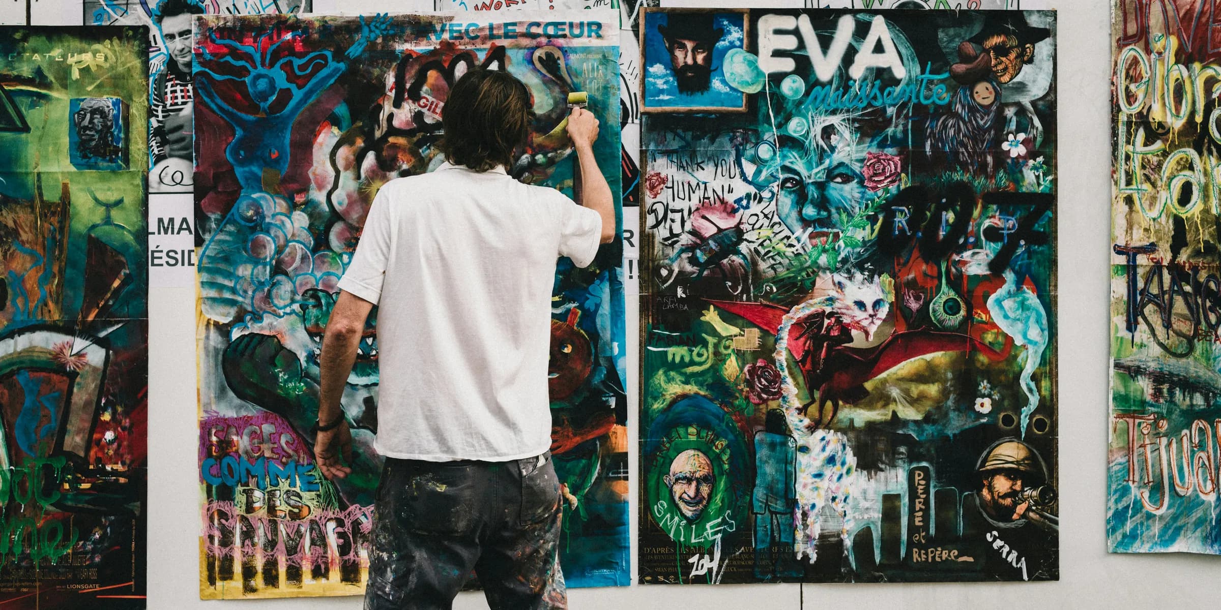 man wearing white shirt painting a wall