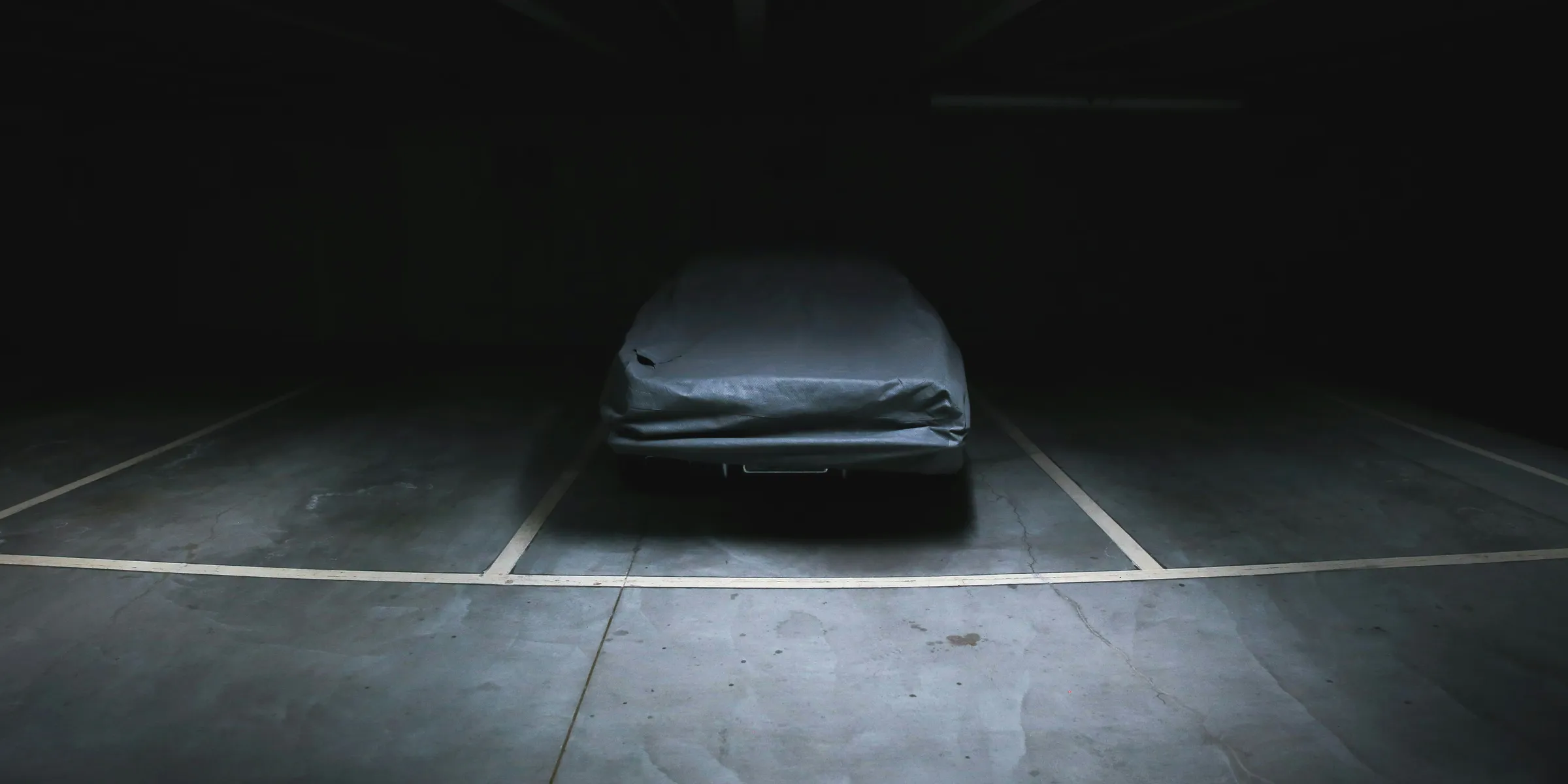 covered vehicle in empty parking lot